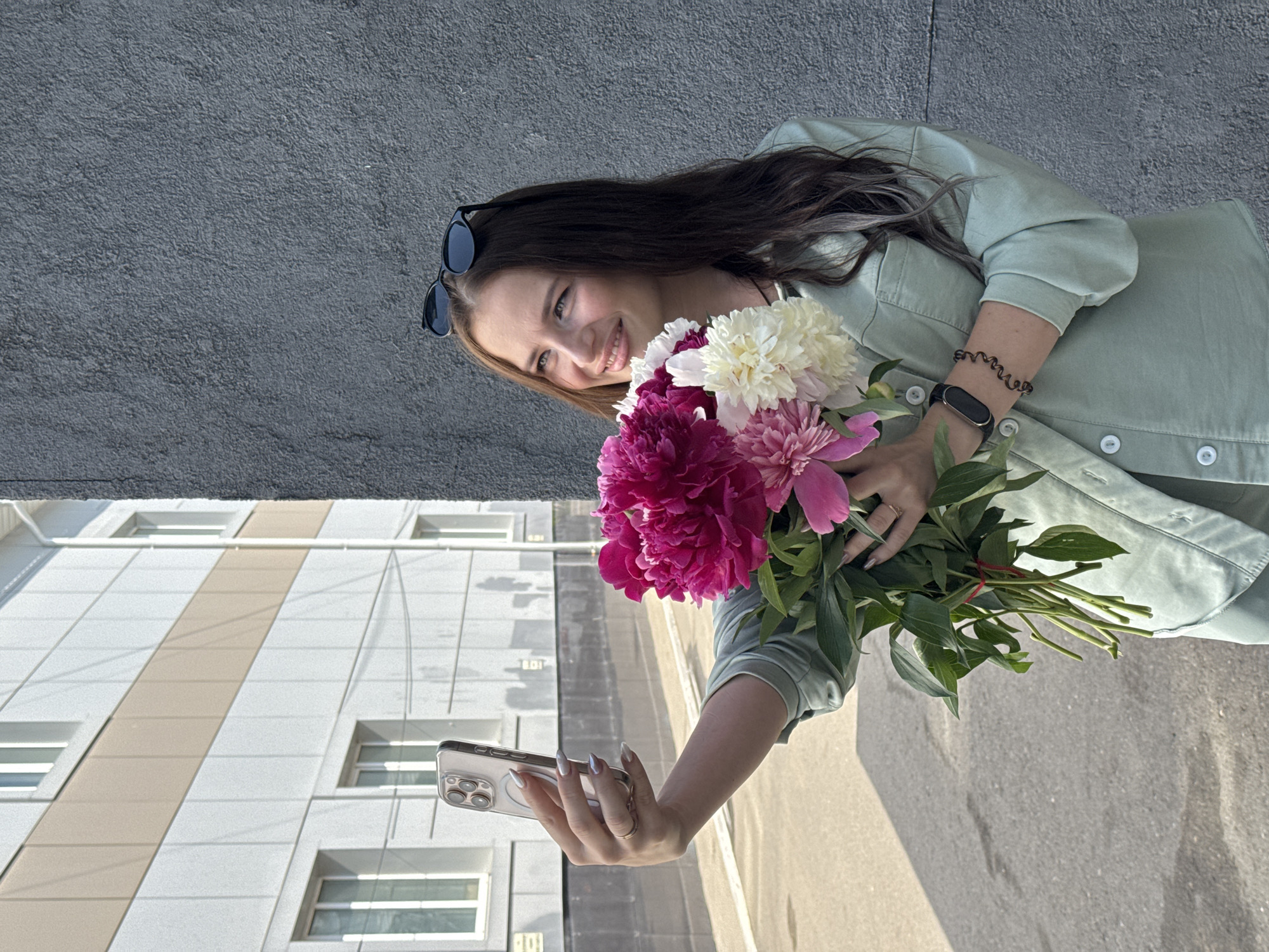 Woman photographs selfies with peony bouquets in Chaikovsky, Russia