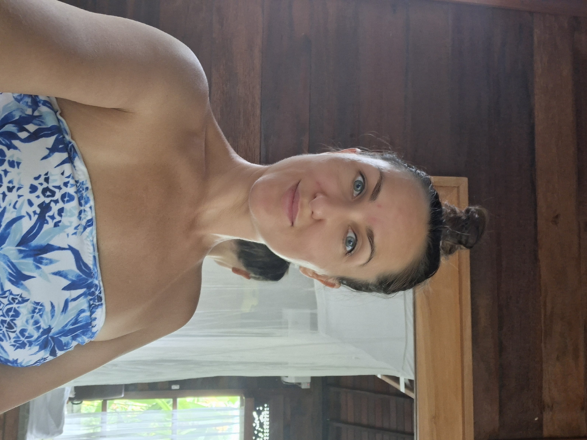 Woman takes morning selfies in rustic Ubud room