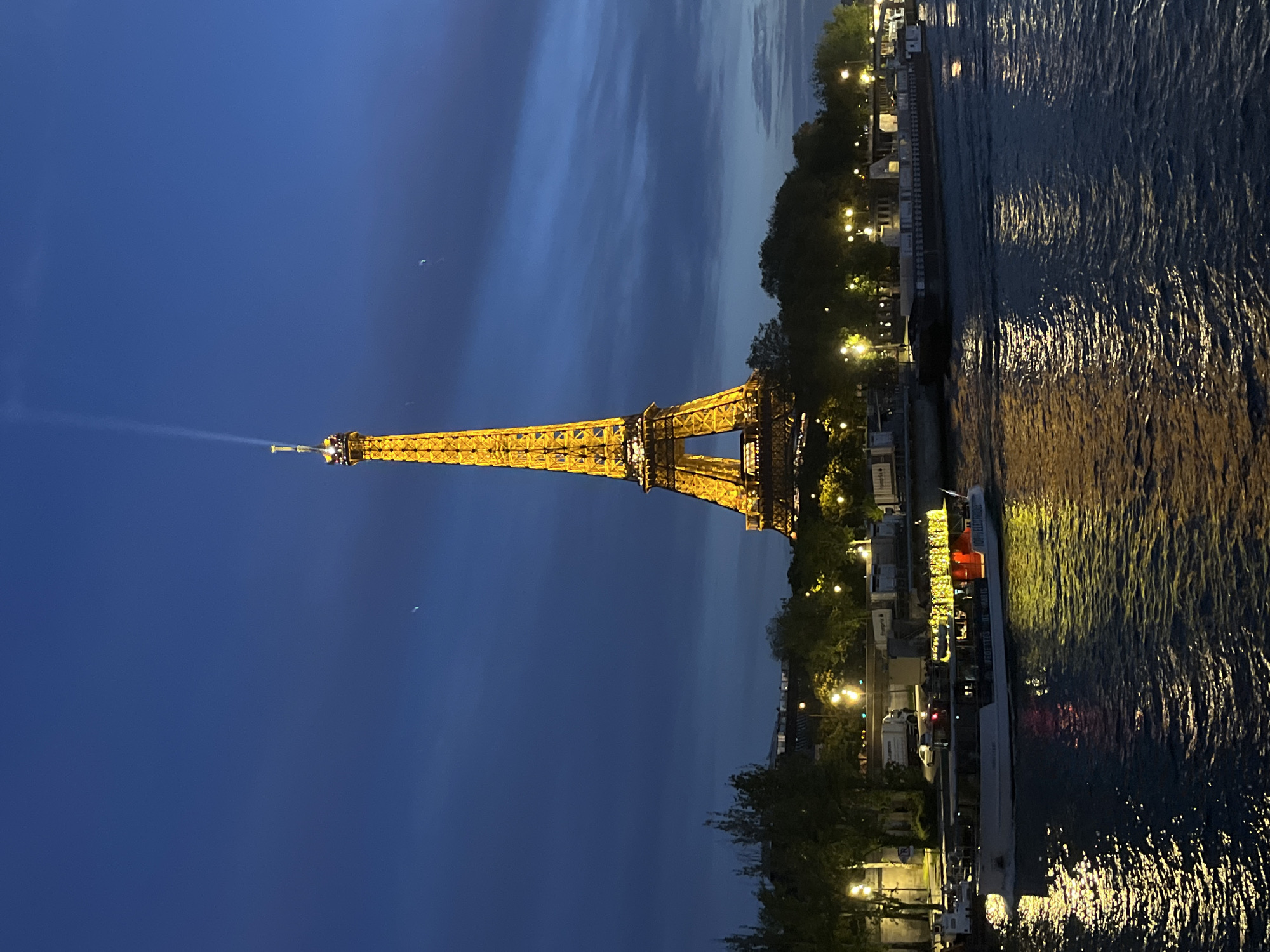 Eiffel Tower glows golden in evening light over Seine