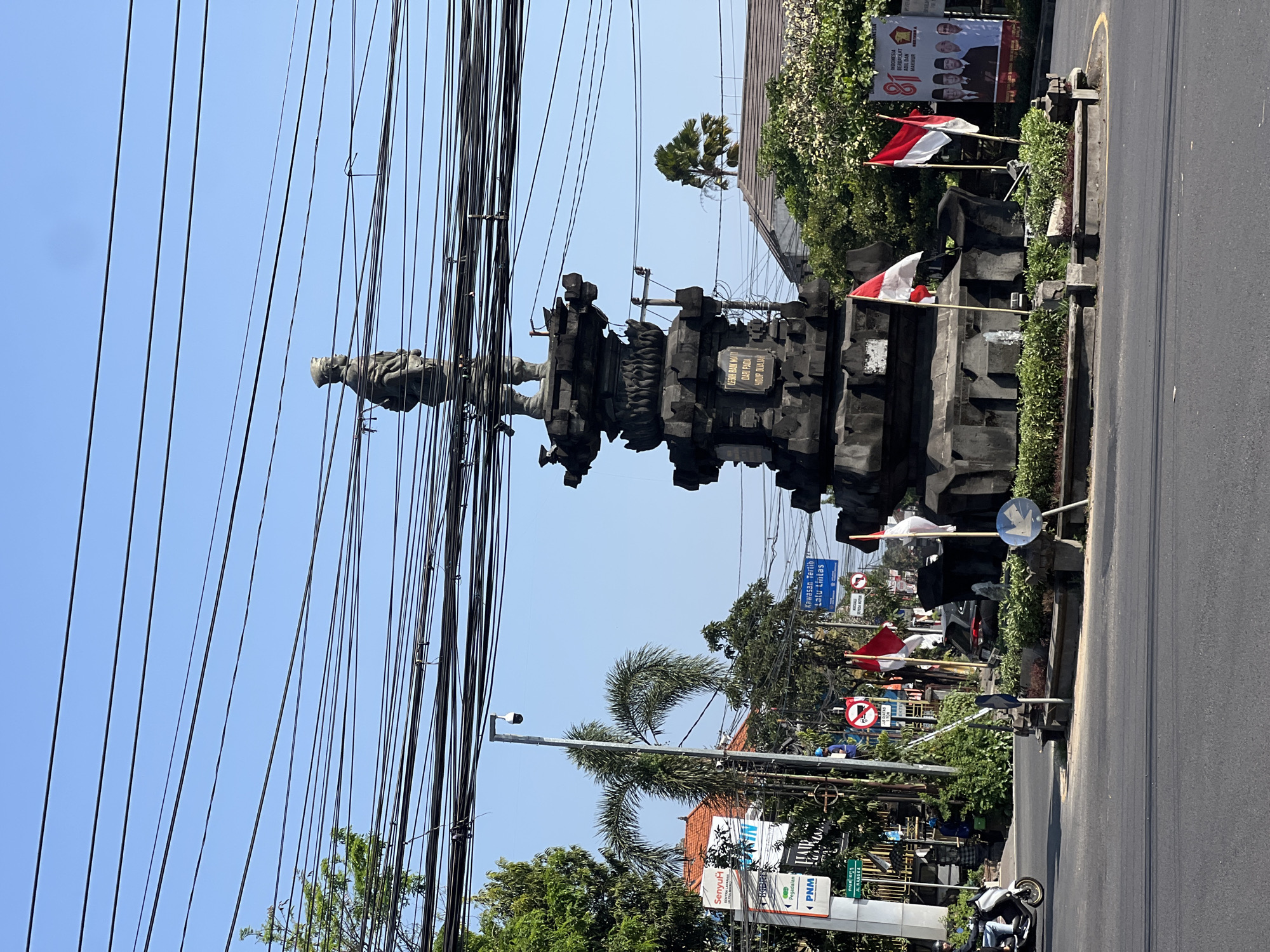 Rush hour traffic circles a landmark monument in central Denpasar