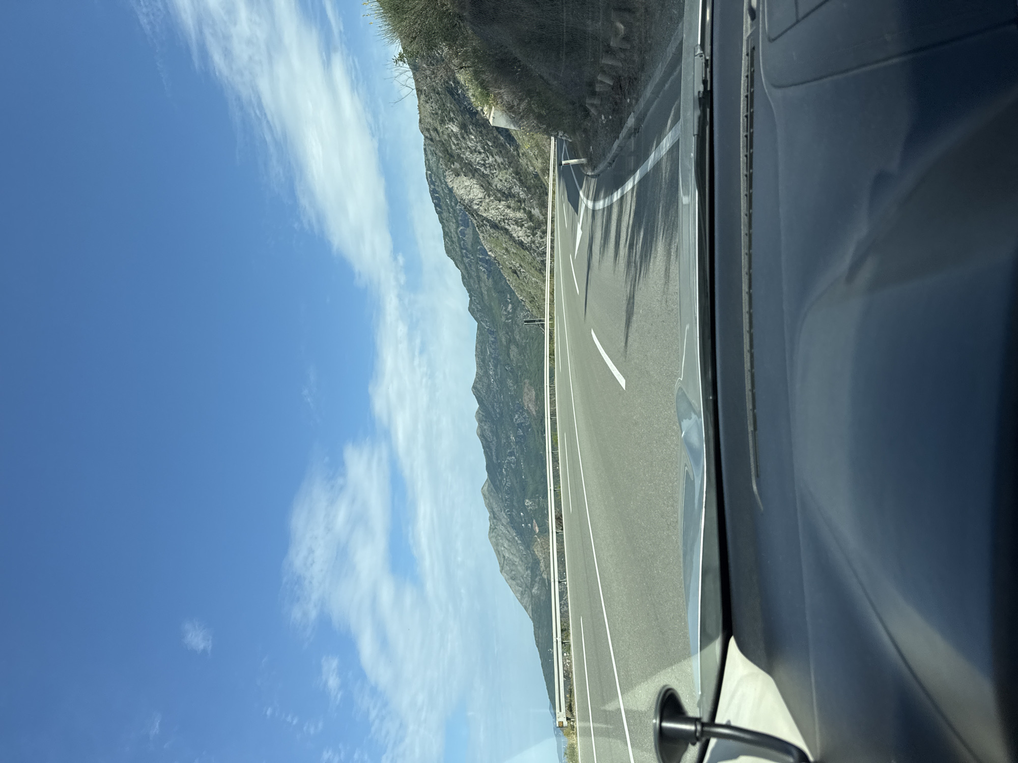 Vehicle travels Montenegro coastal roads past mountains and Adriatic Sea