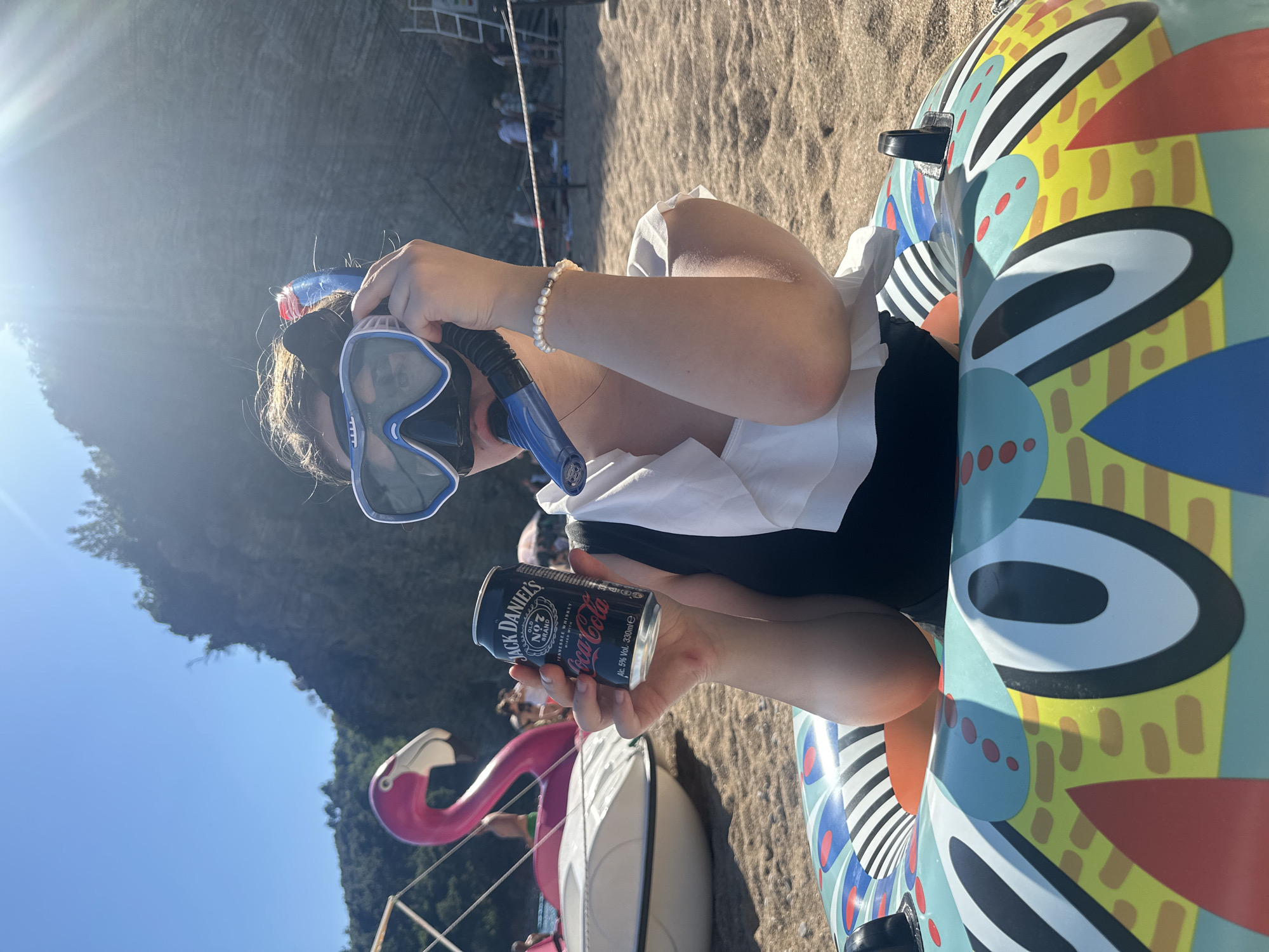 Woman enjoys beach day with drinks in Budva