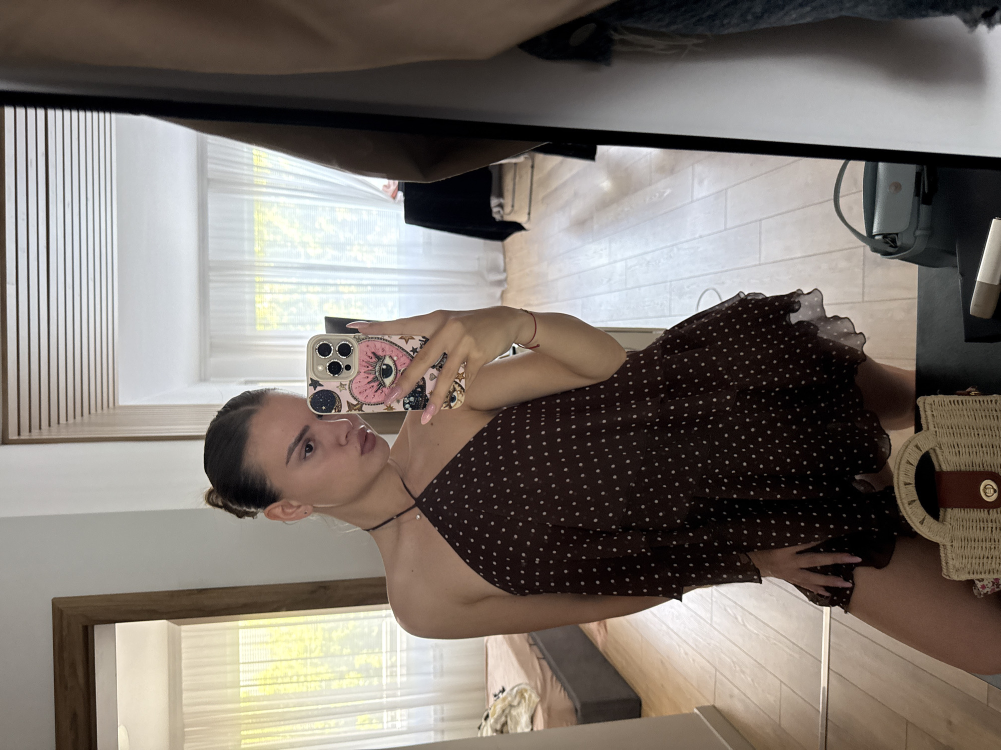 Woman takes mirror selfie in polka-dot dress