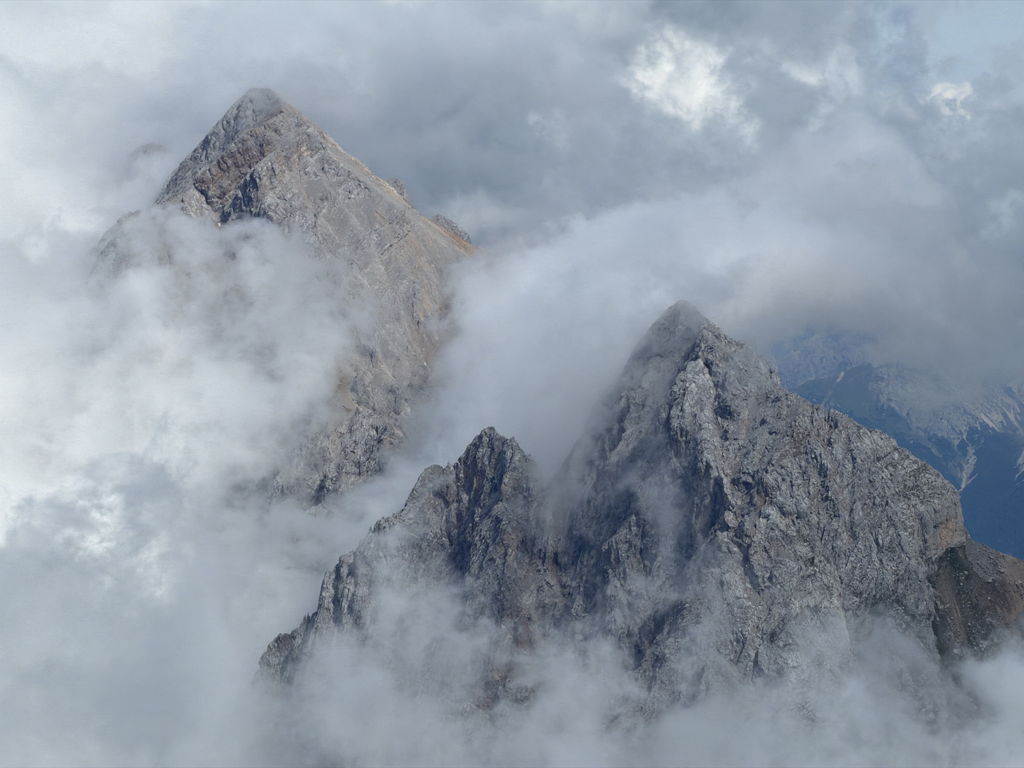 Zugspitze peaks disappear into summer cloud and fog