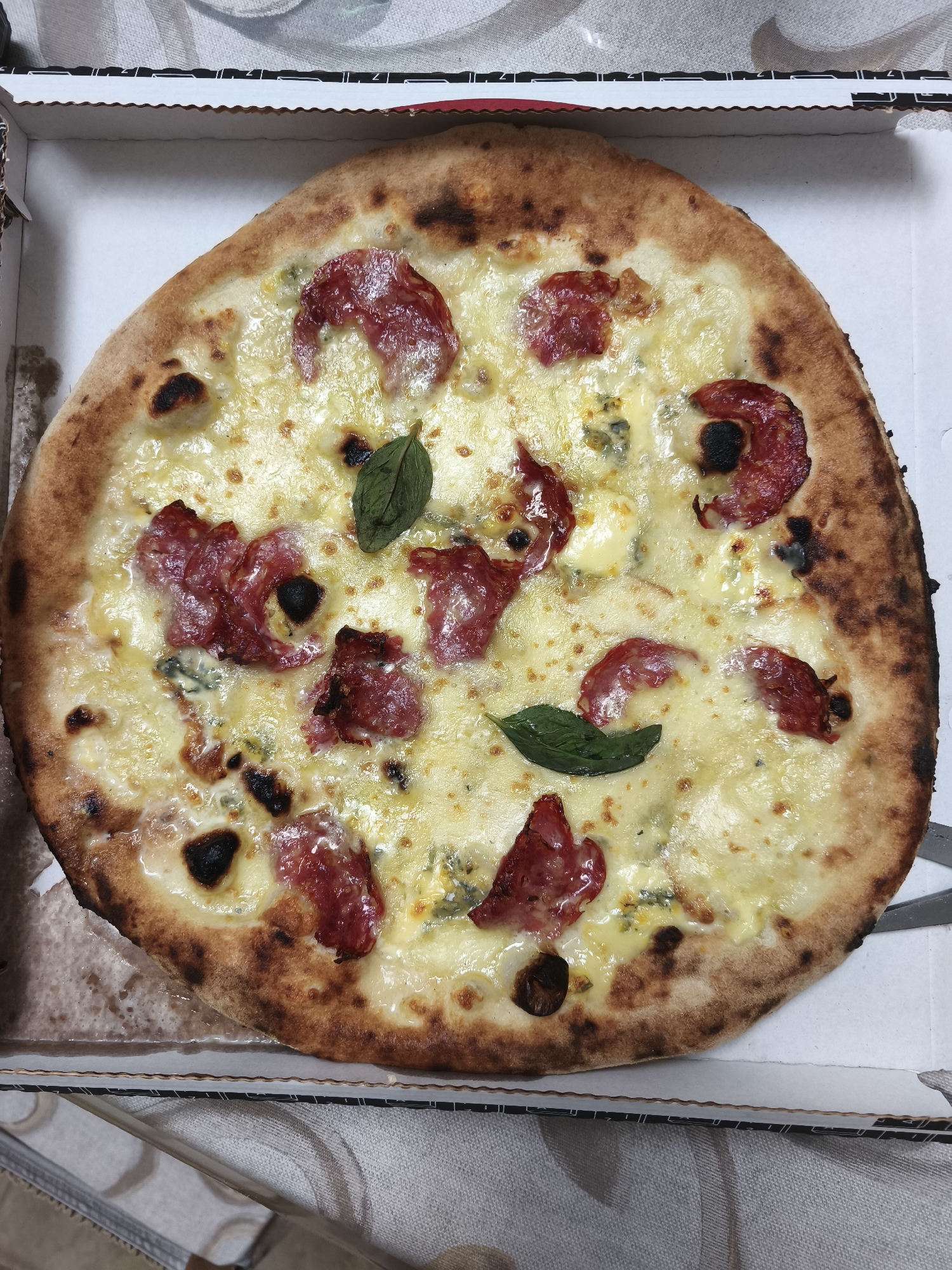 Fresh salami pizza in takeout box, Campochiaro Italy