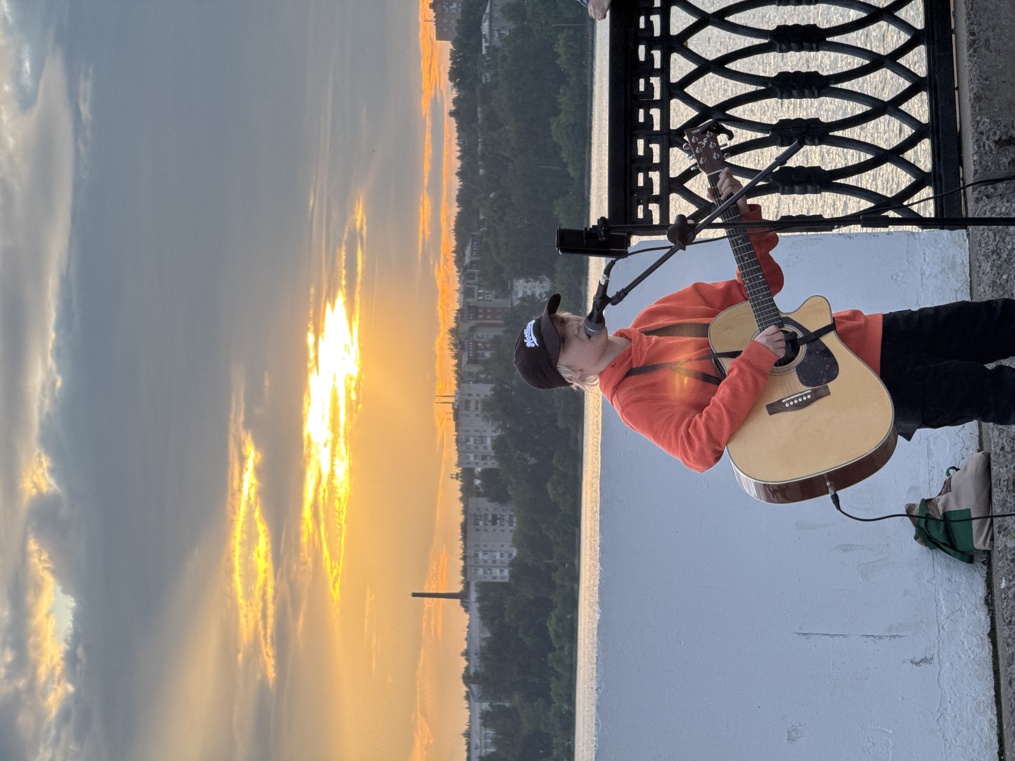 Street musician performs during sunset on Izhevsk riverfront embankment