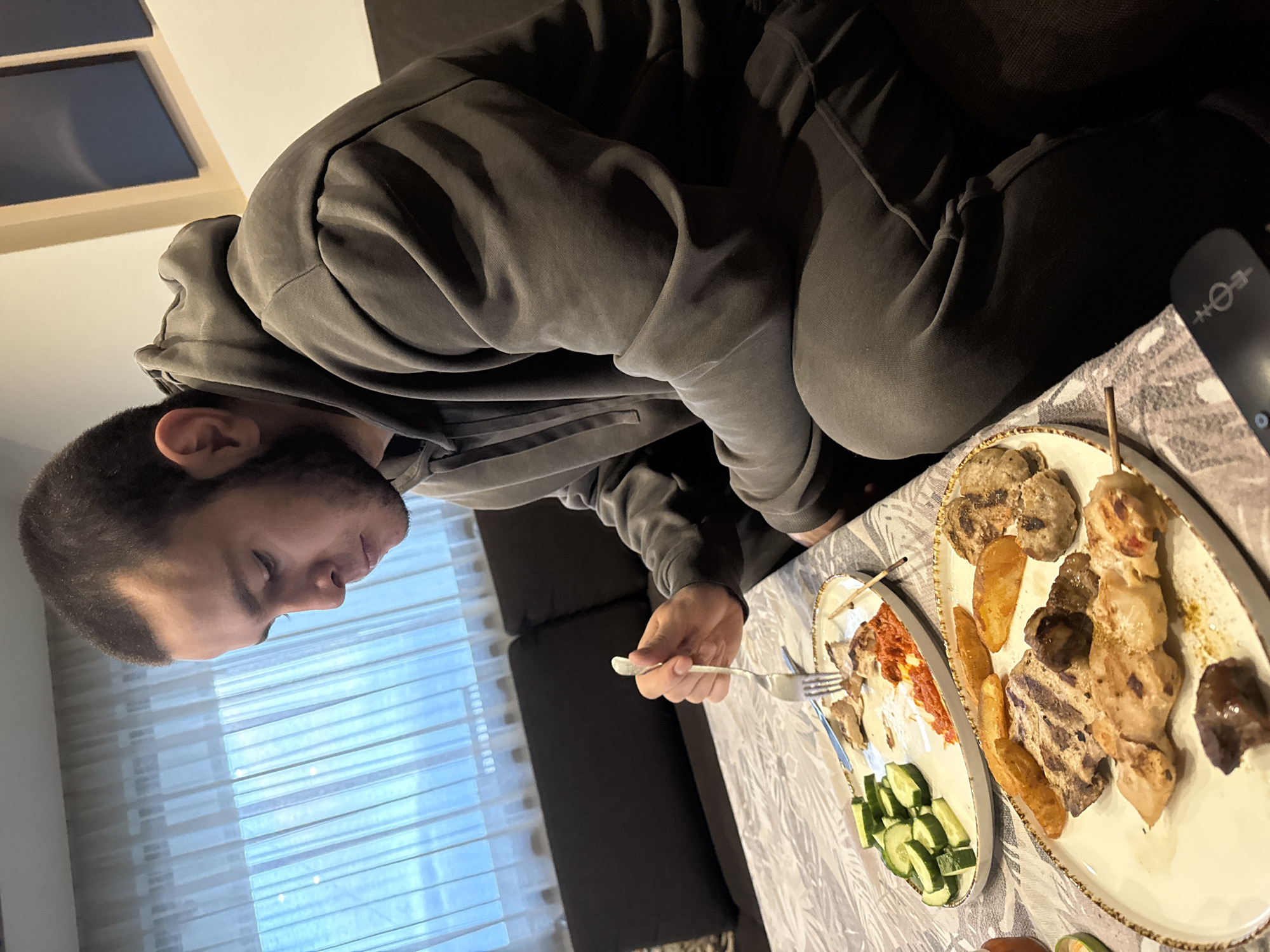 Man enjoys home meal on couch in Burgas