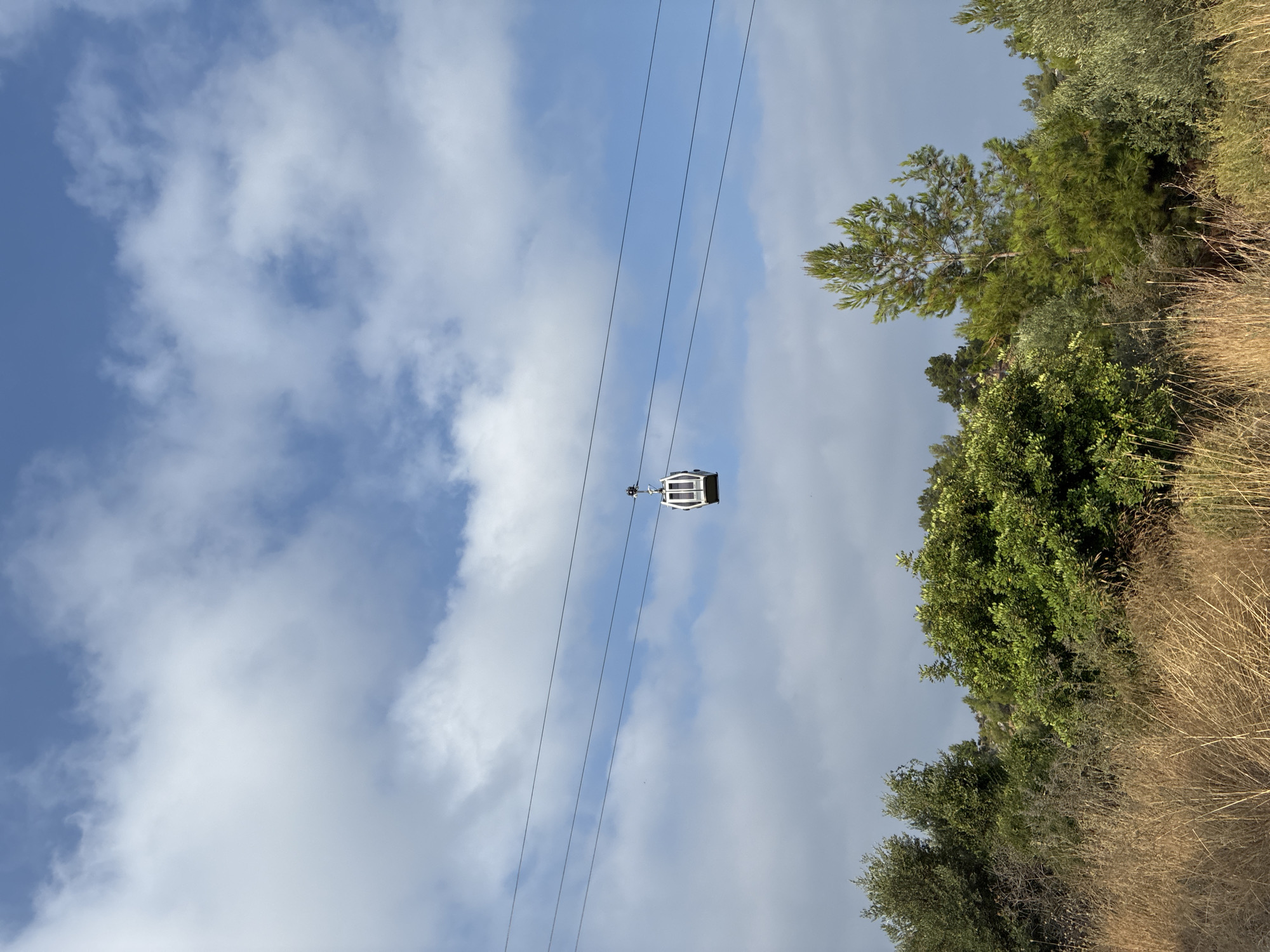Cable cars glide above Alanya's coastal hillside on a summer morning.