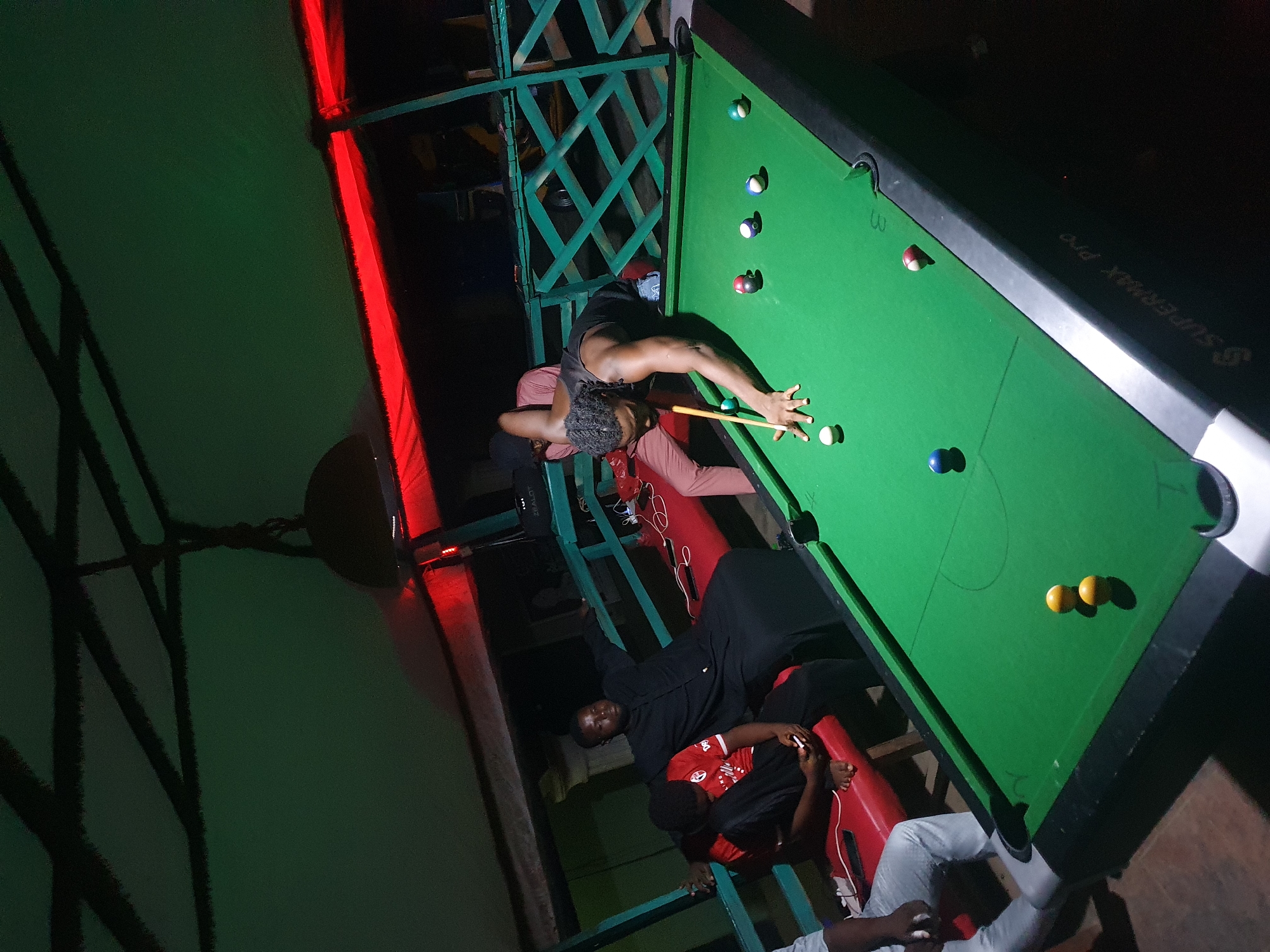 Men play casual pool game at Lokoja venue