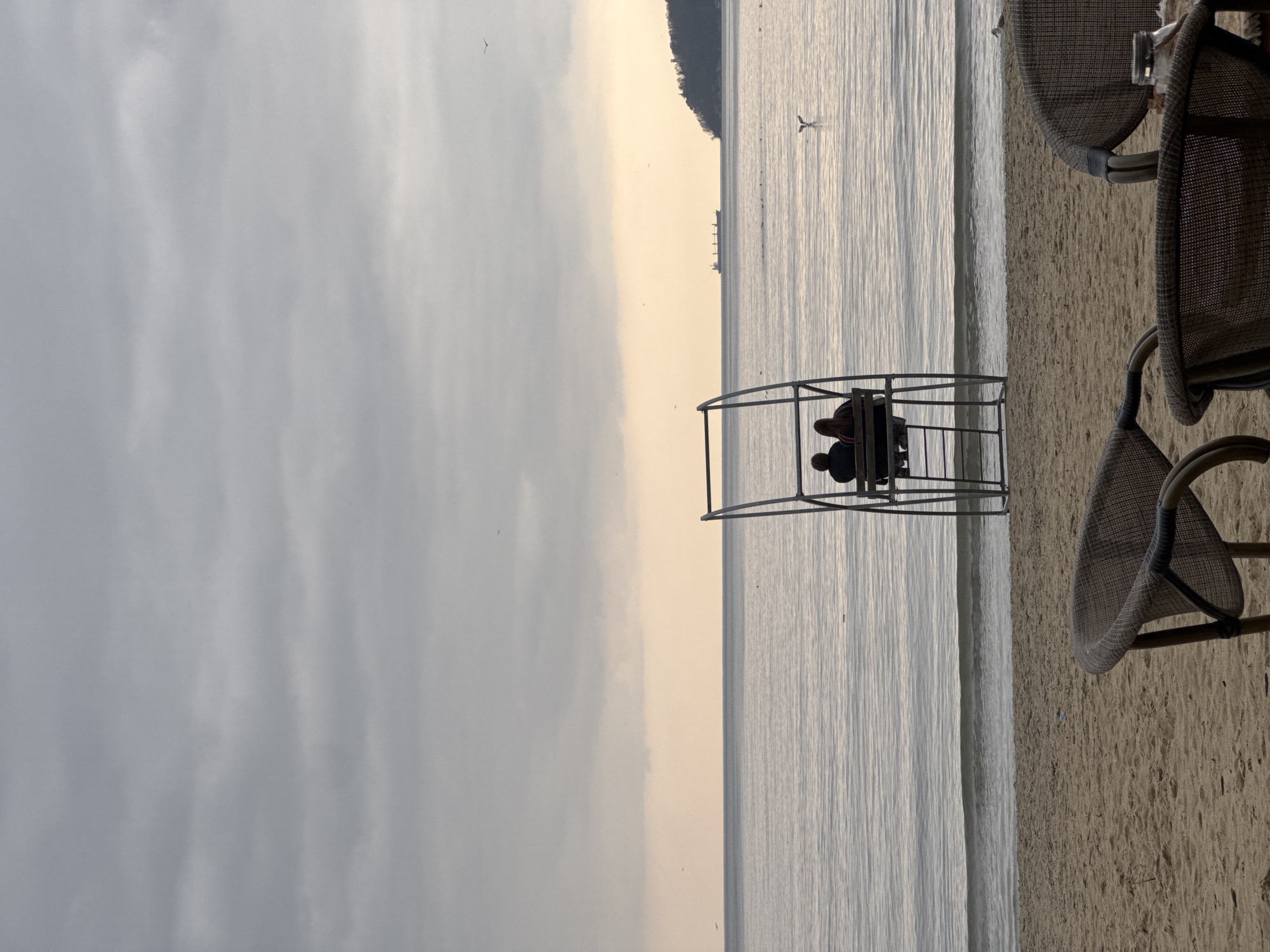 Couple sits in beach structure overlooking water in Varna