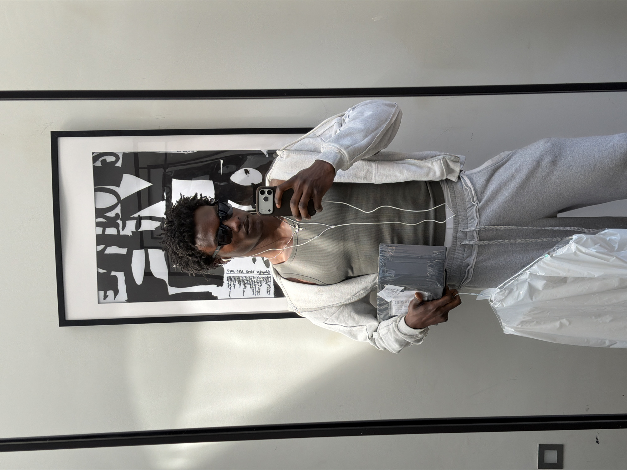 Man in grey sweatsuit photographed in mirror, London