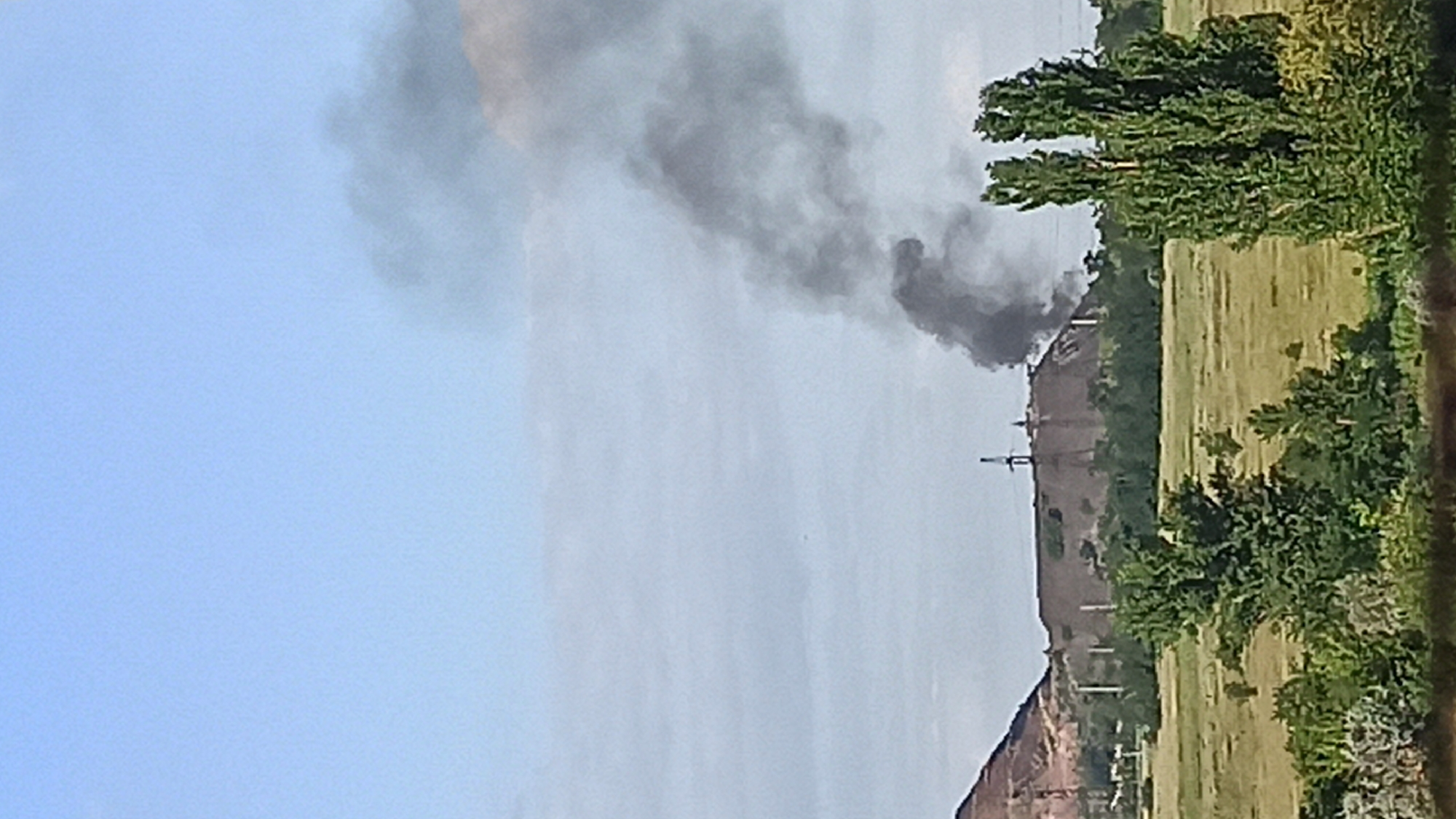 Smoking industrial slag heap documented alongside urban residential area