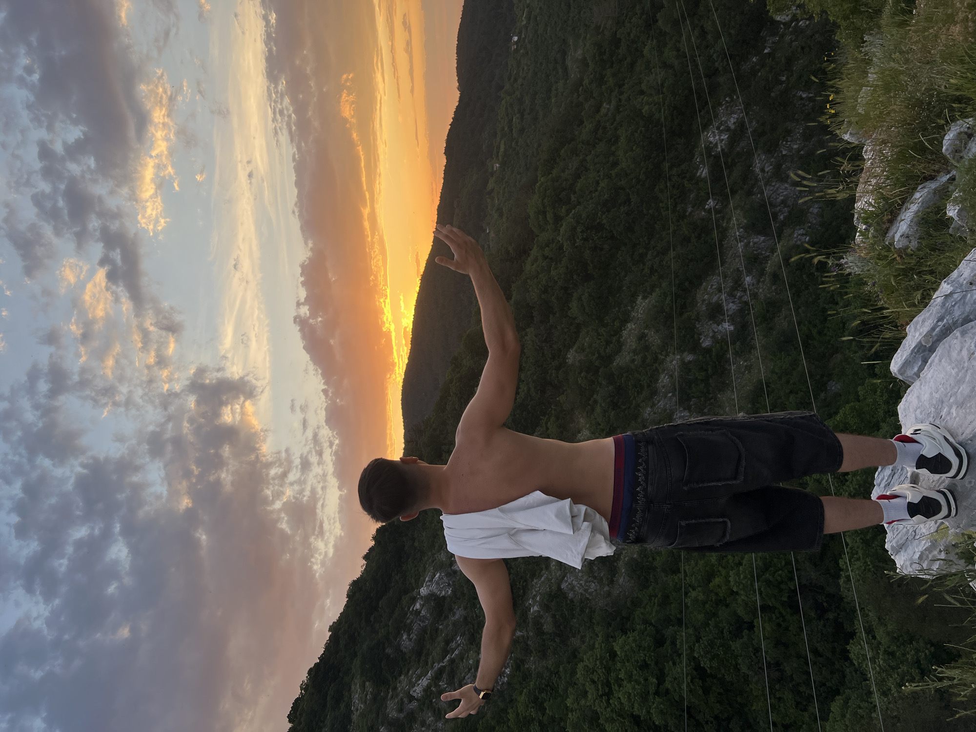 Hiker enjoys sunset views from rocky outcrop near Asenovgrad