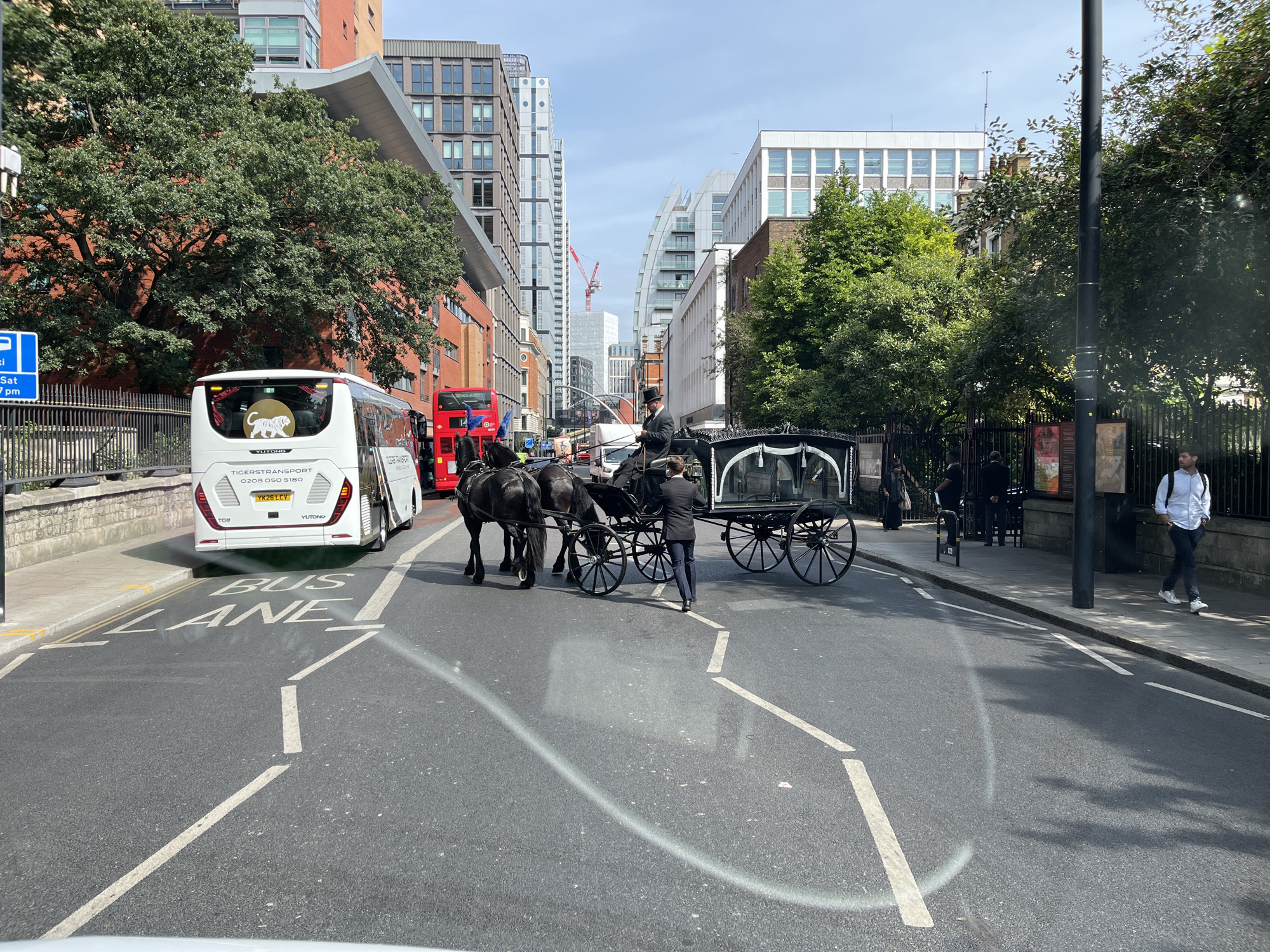 Bus lane and white bus on a clear London street