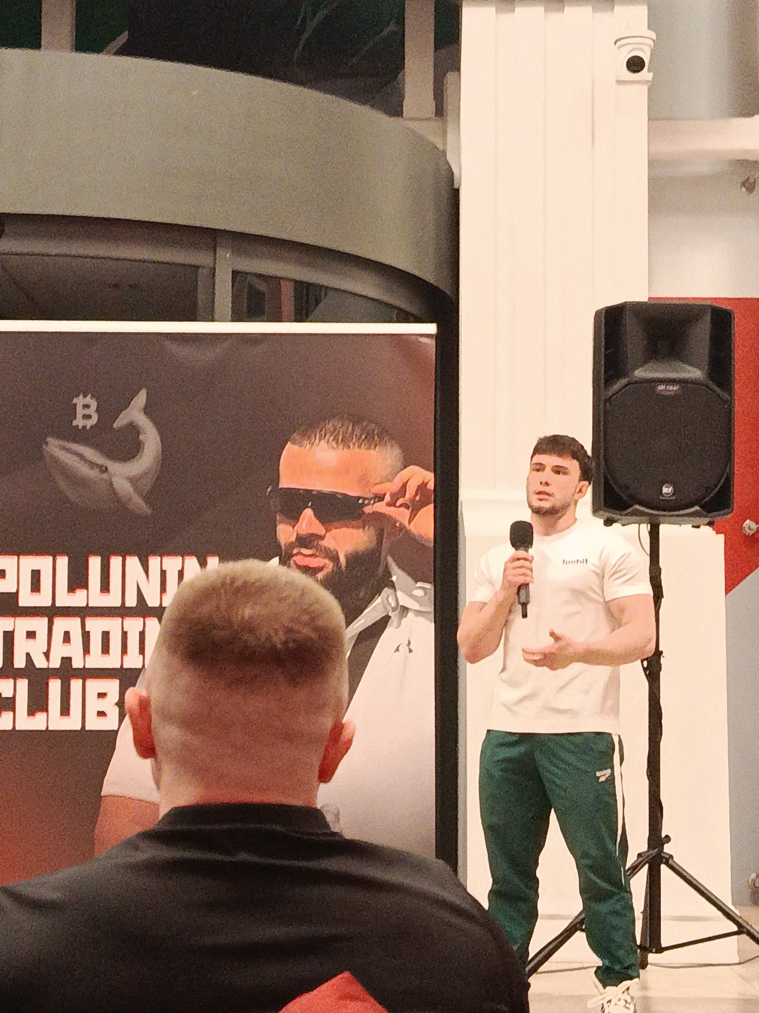 Man in football shirt speaks at cryptocurrency event