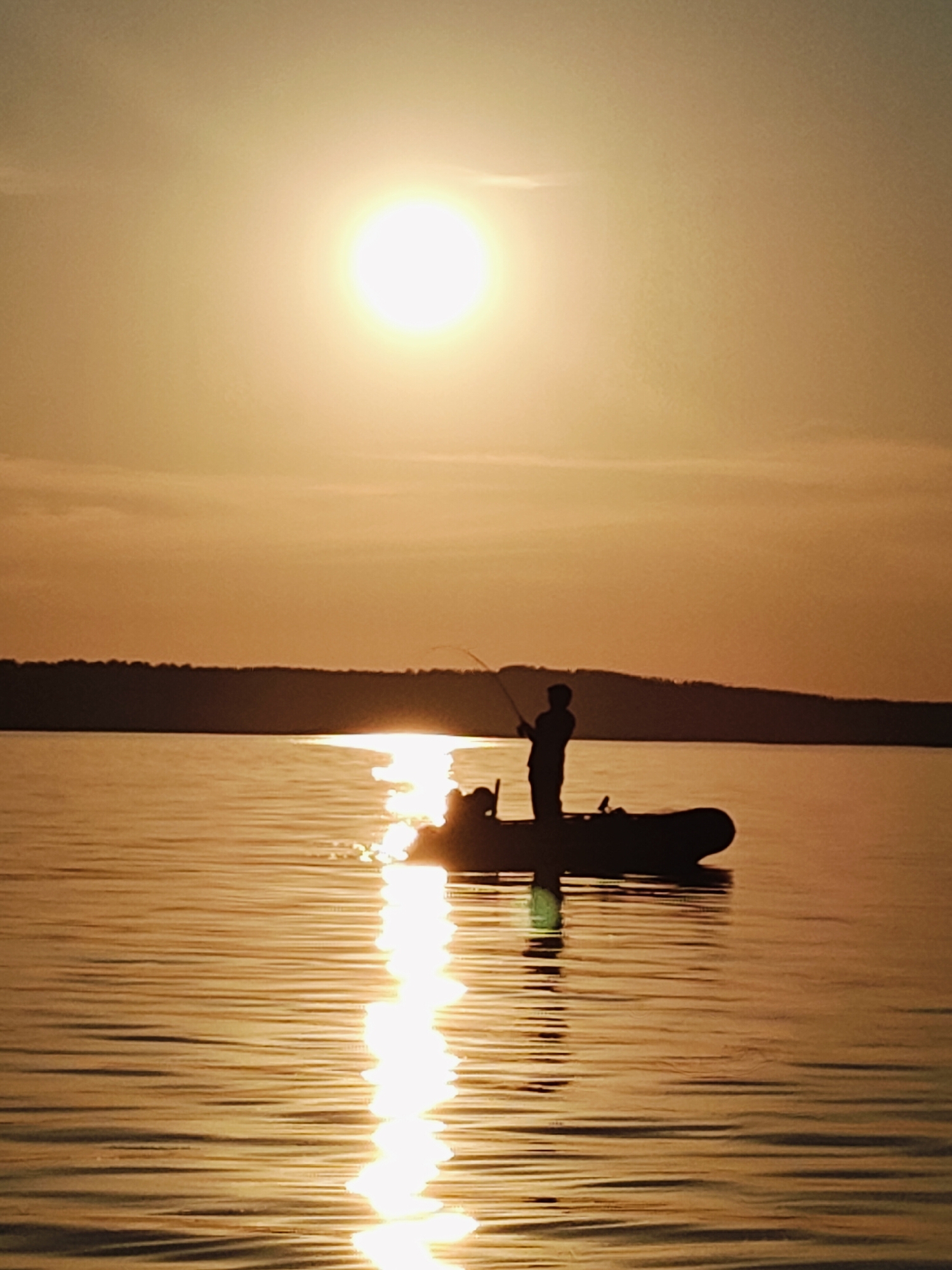 Quiet evening fishing on a glassy river at golden hour