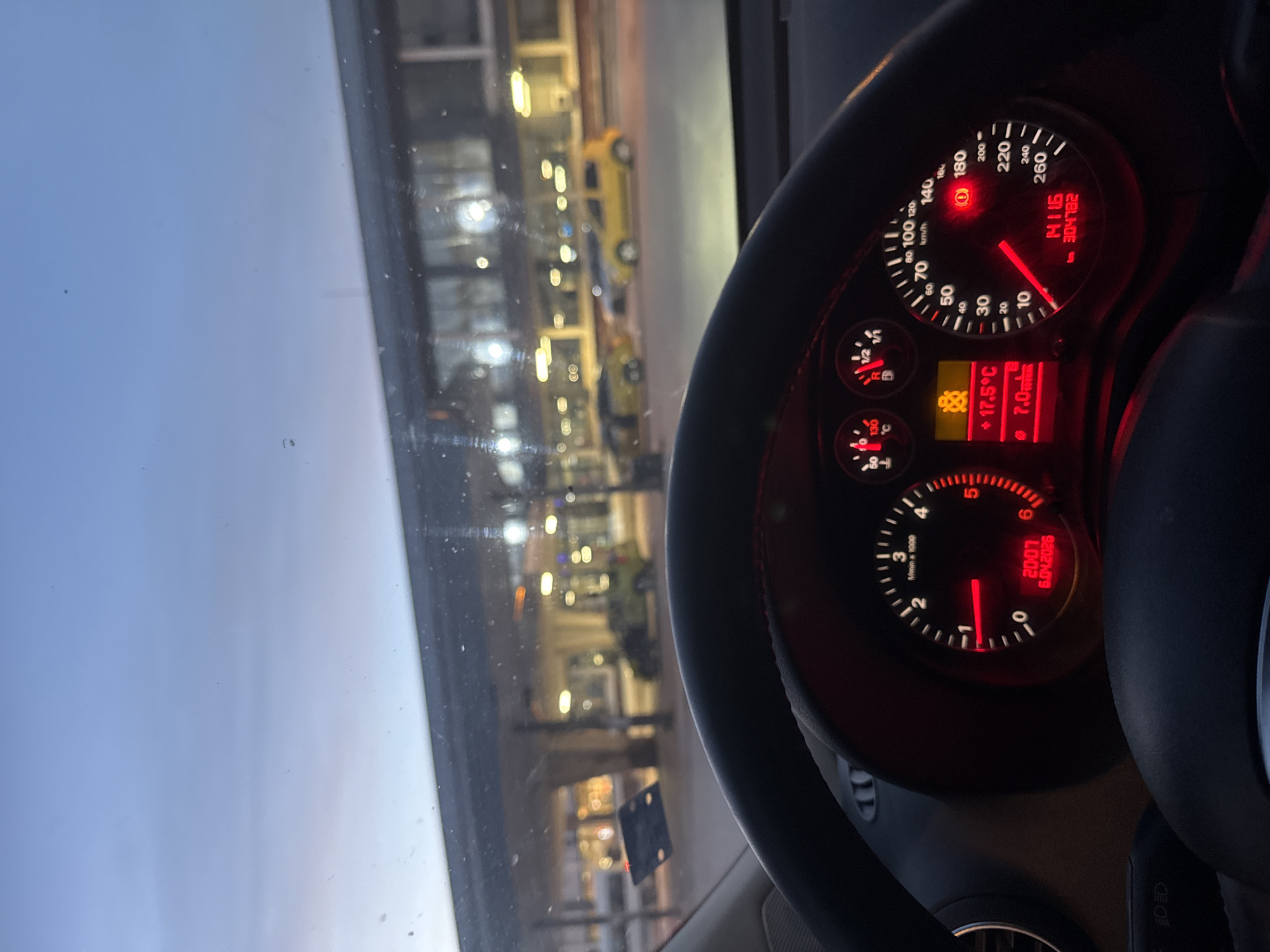 Vehicle dashboard observed while stationary, instruments illuminated