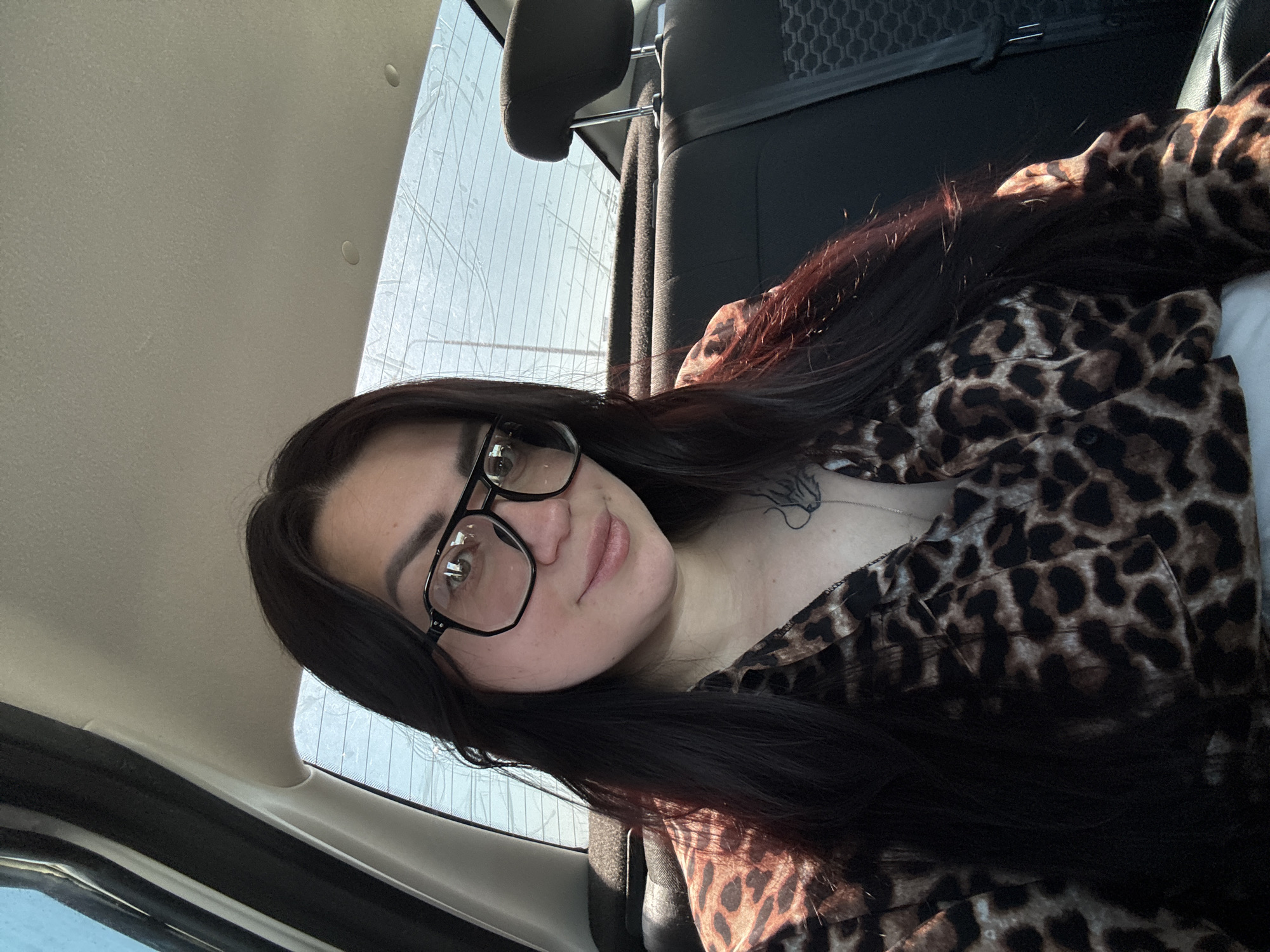 Woman in leopard-print shirt photographed inside vehicle