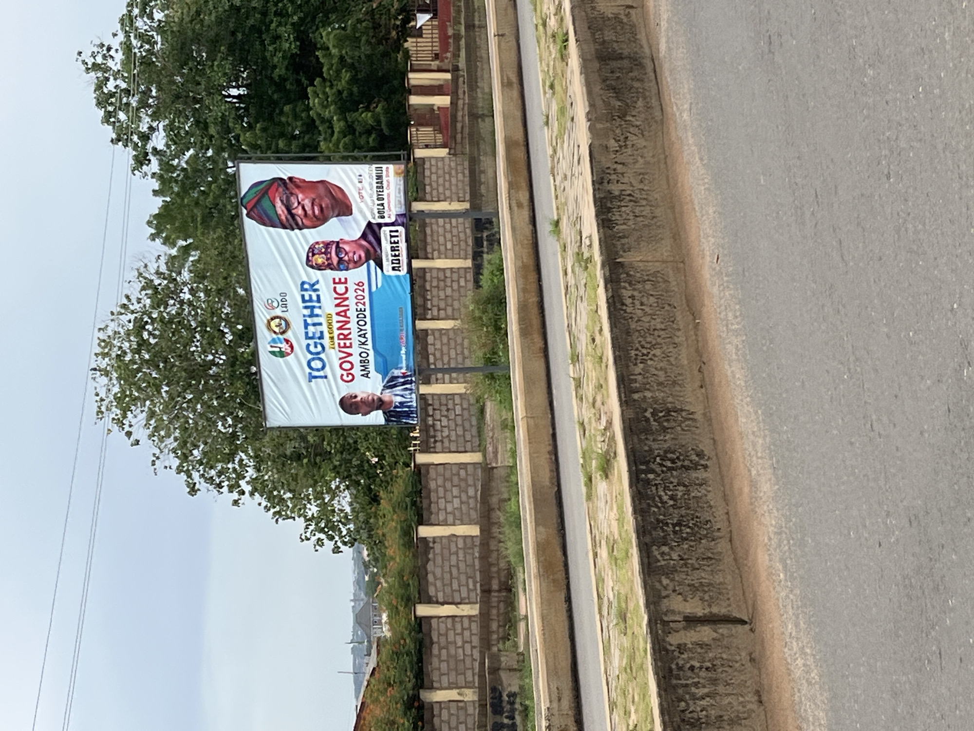 Political billboard spotted on empty road in Offatedo, Nigeria