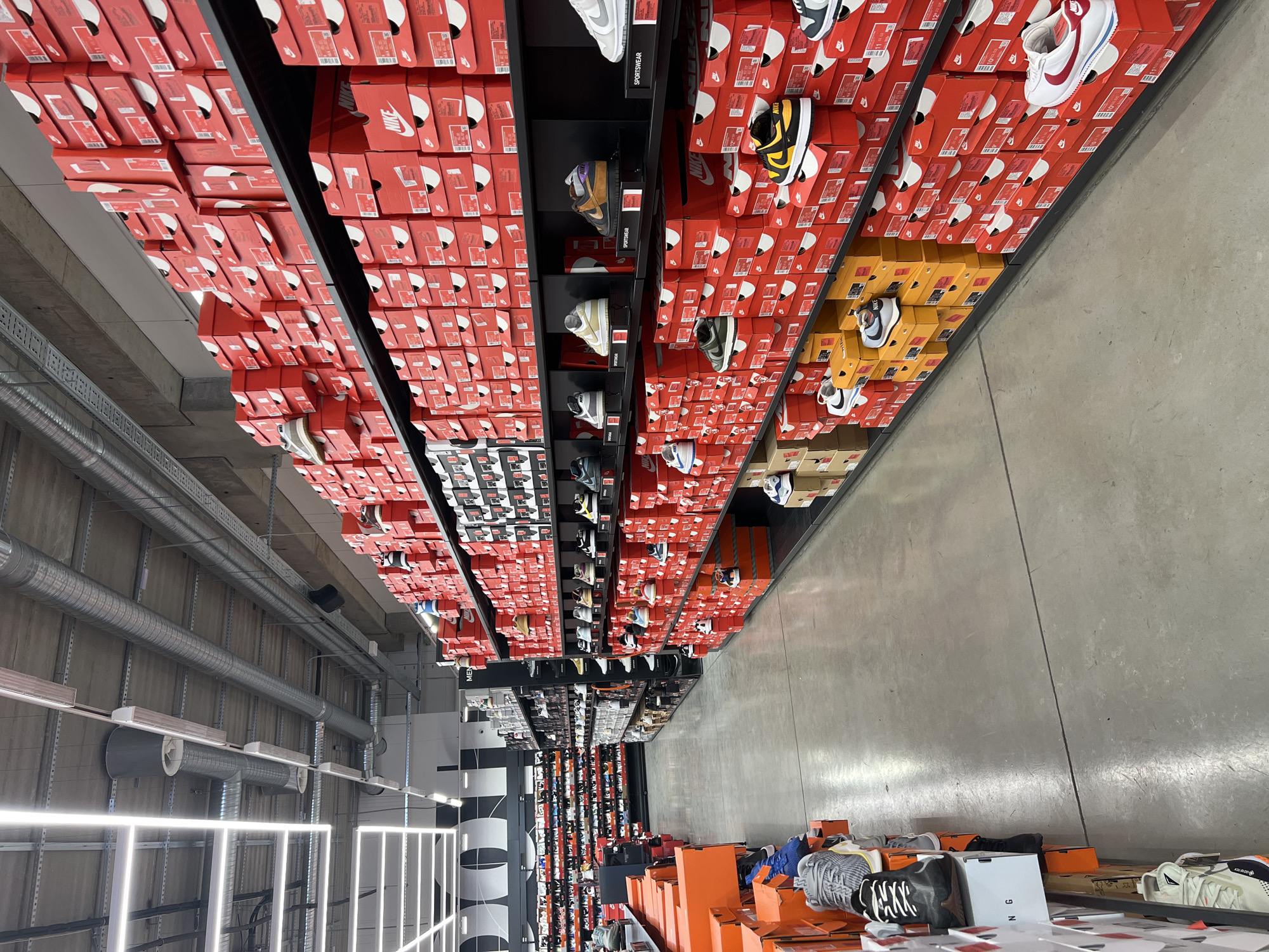 Nike store interior shows organized red shoebox display