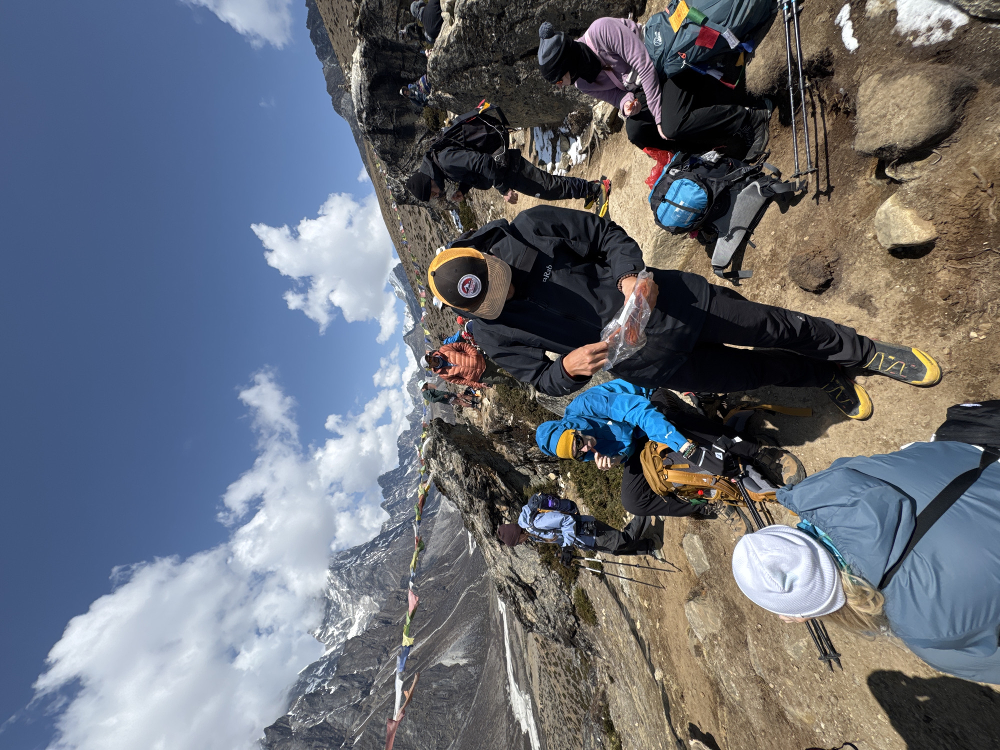 Hikers rest on steep mountain trail near Khumjung, Nepal