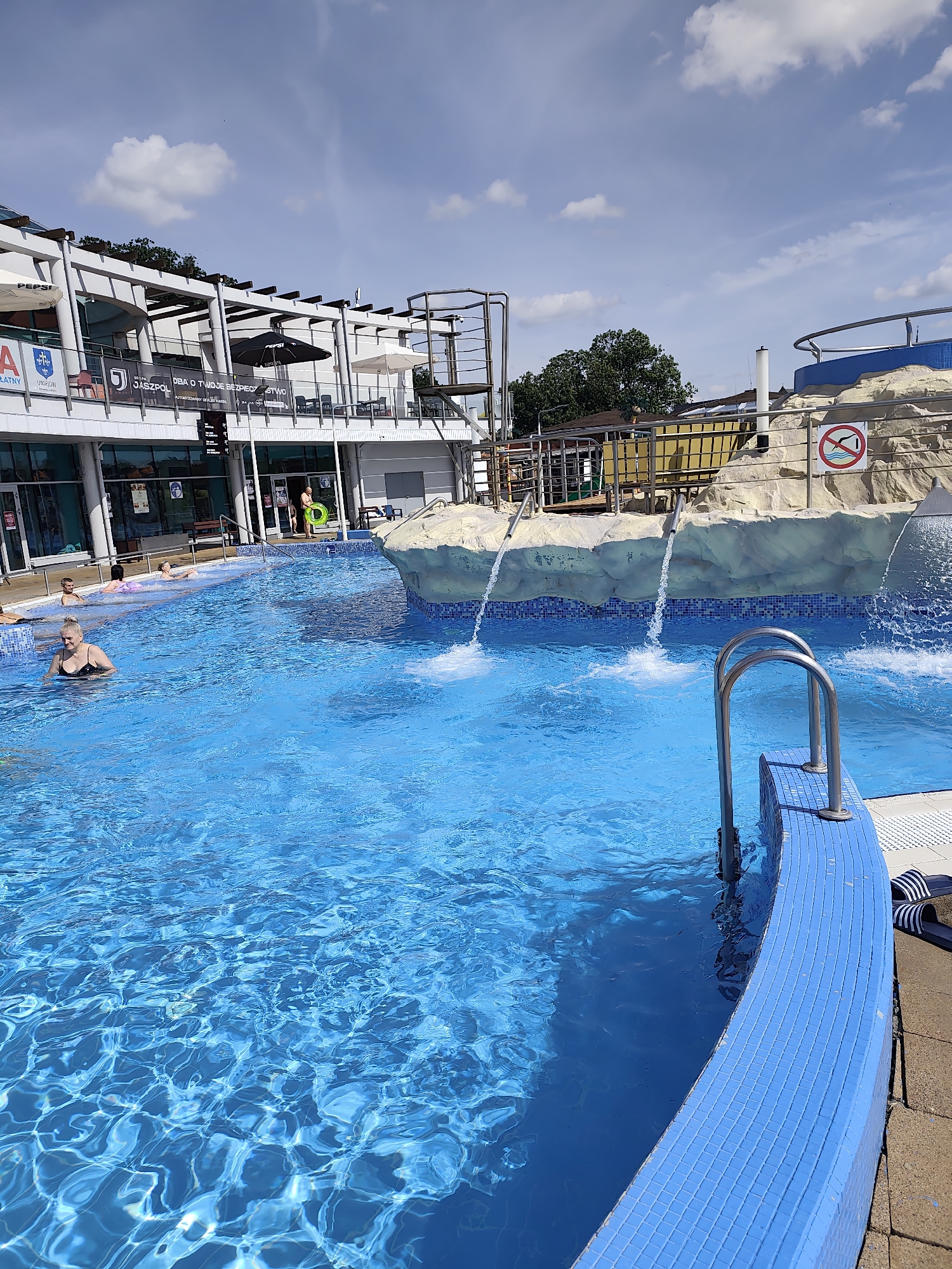 Outdoor pool and gym complex on a sunny morning