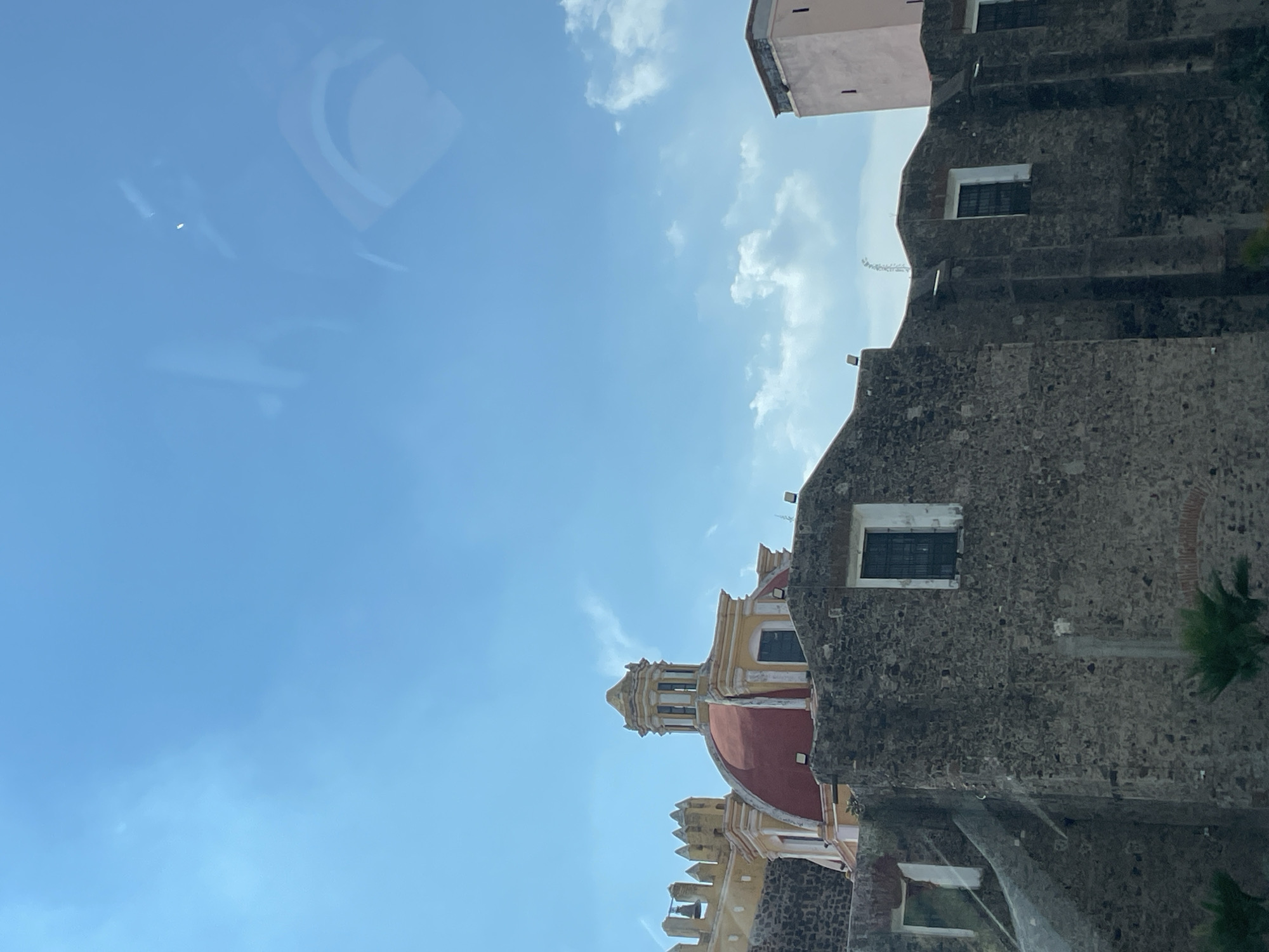 Tourist photographs historic Cholula church and pyramid complex