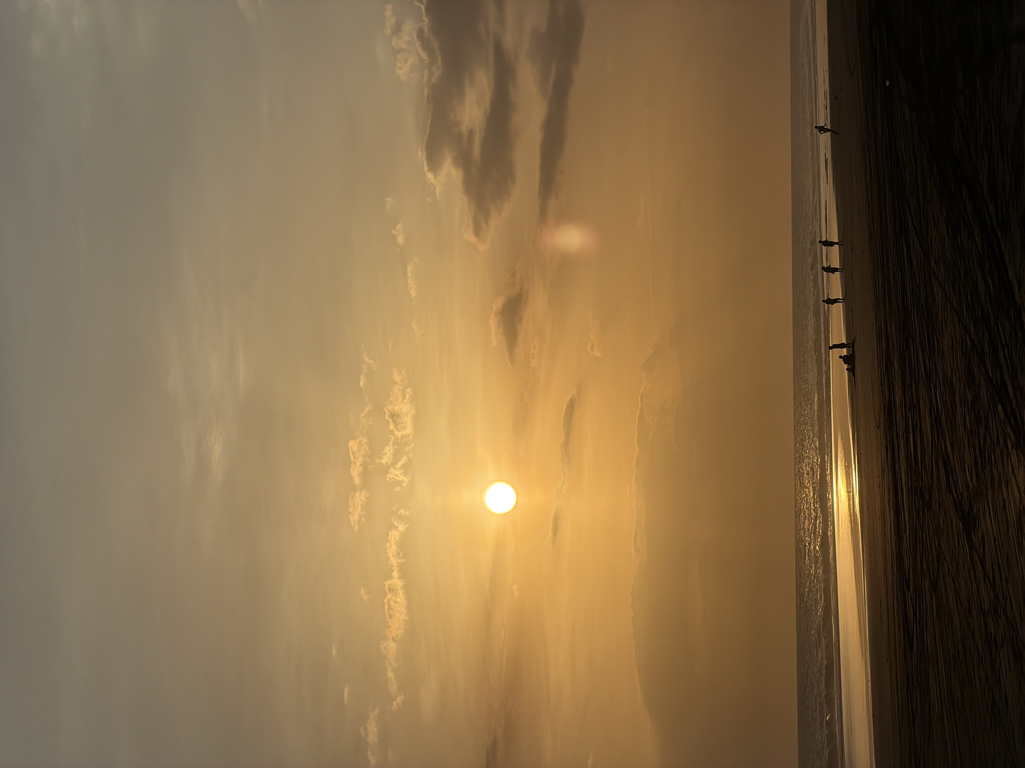 Golden sunset observed through clouds at Indonesian beach