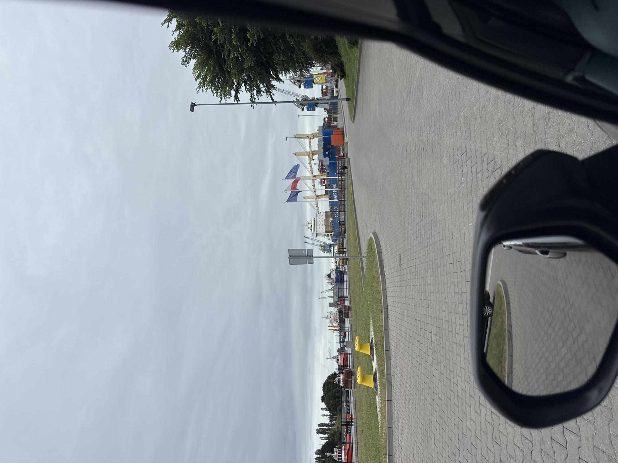 Passing Gdańsk's working harbor with coast guard vessels docked nearby