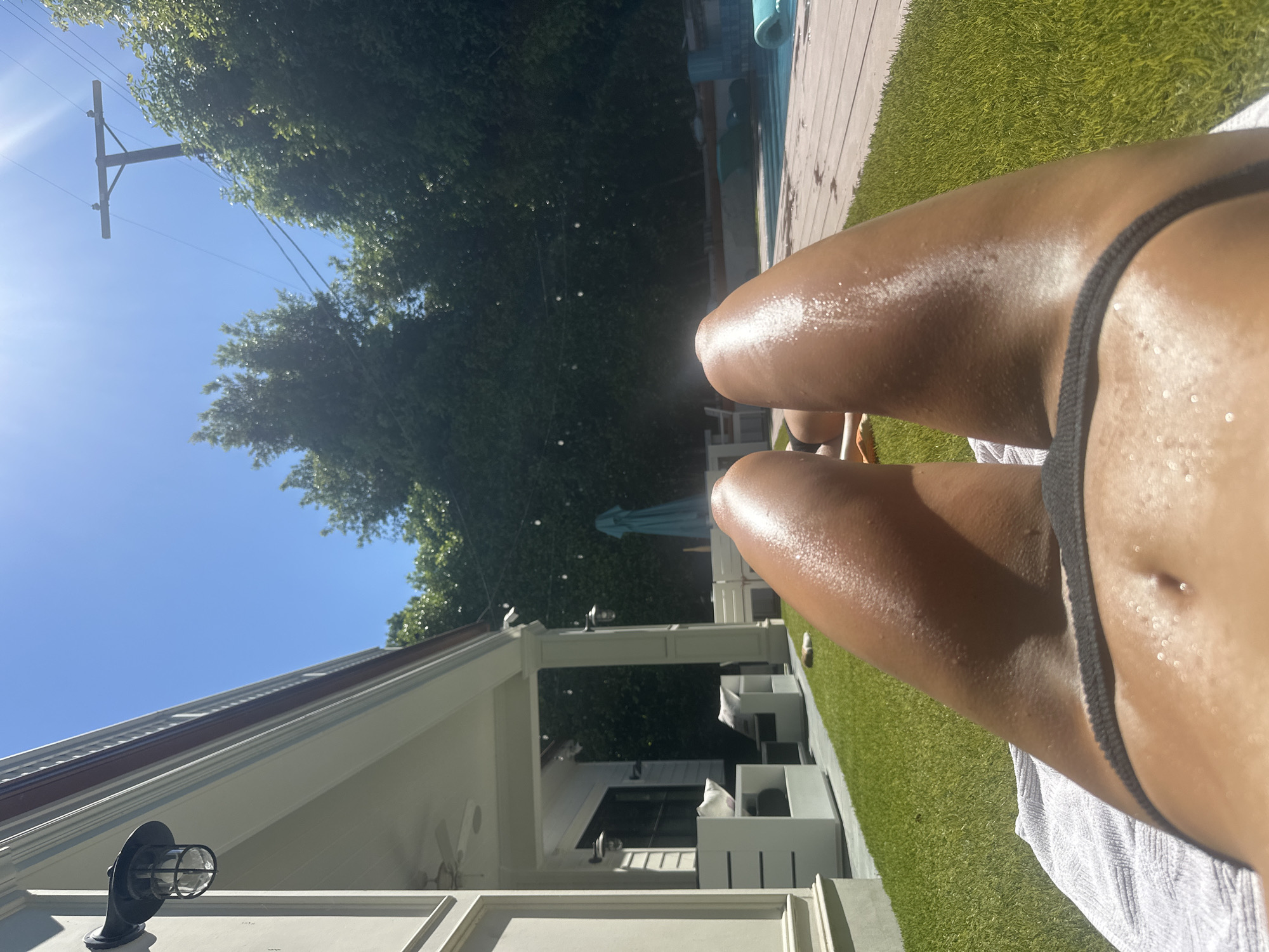 Person sunbathing on artificial turf in Los Angeles backyard