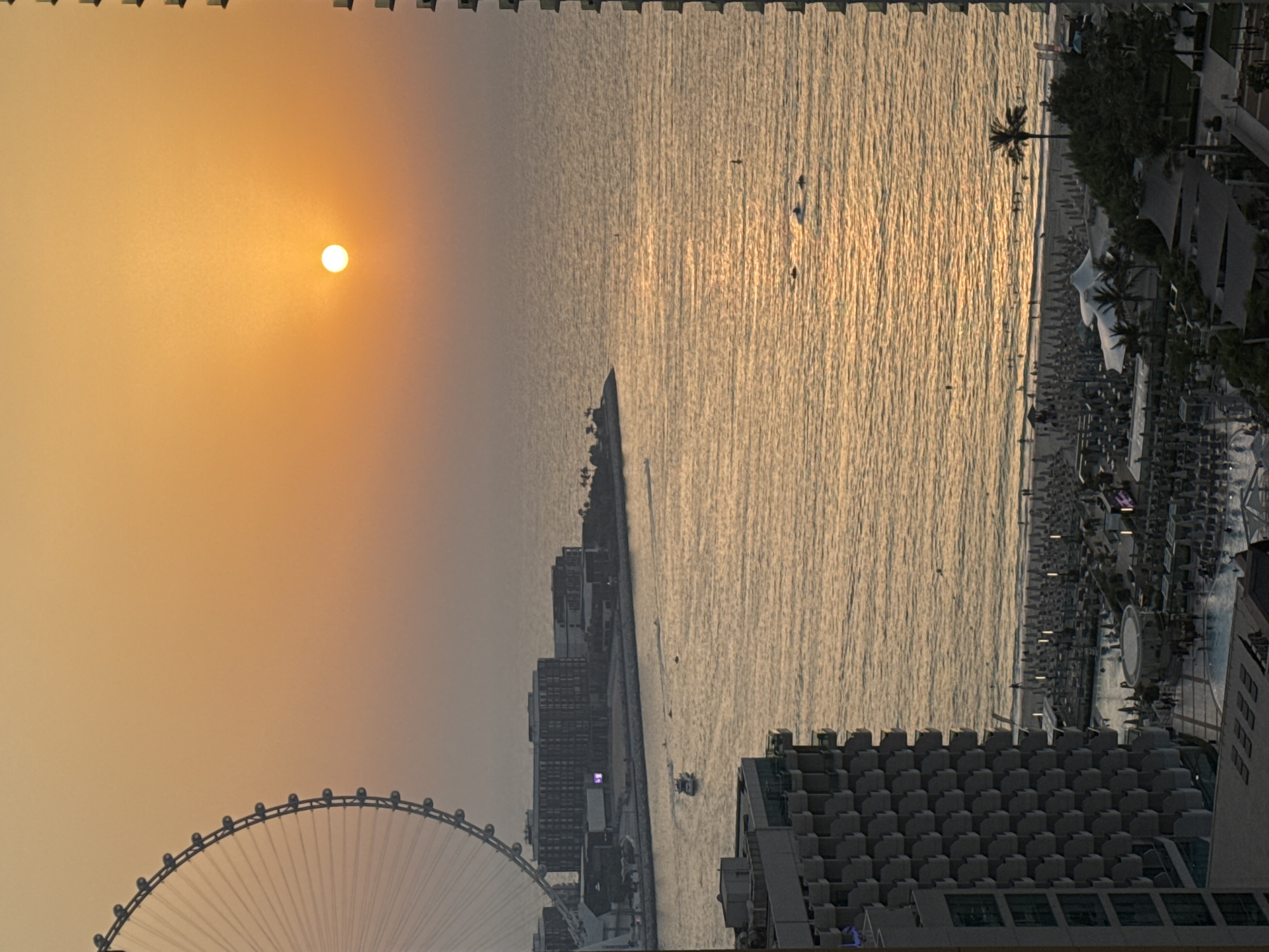 Dubai waterfront glows at sunset, Ain Dubai in view