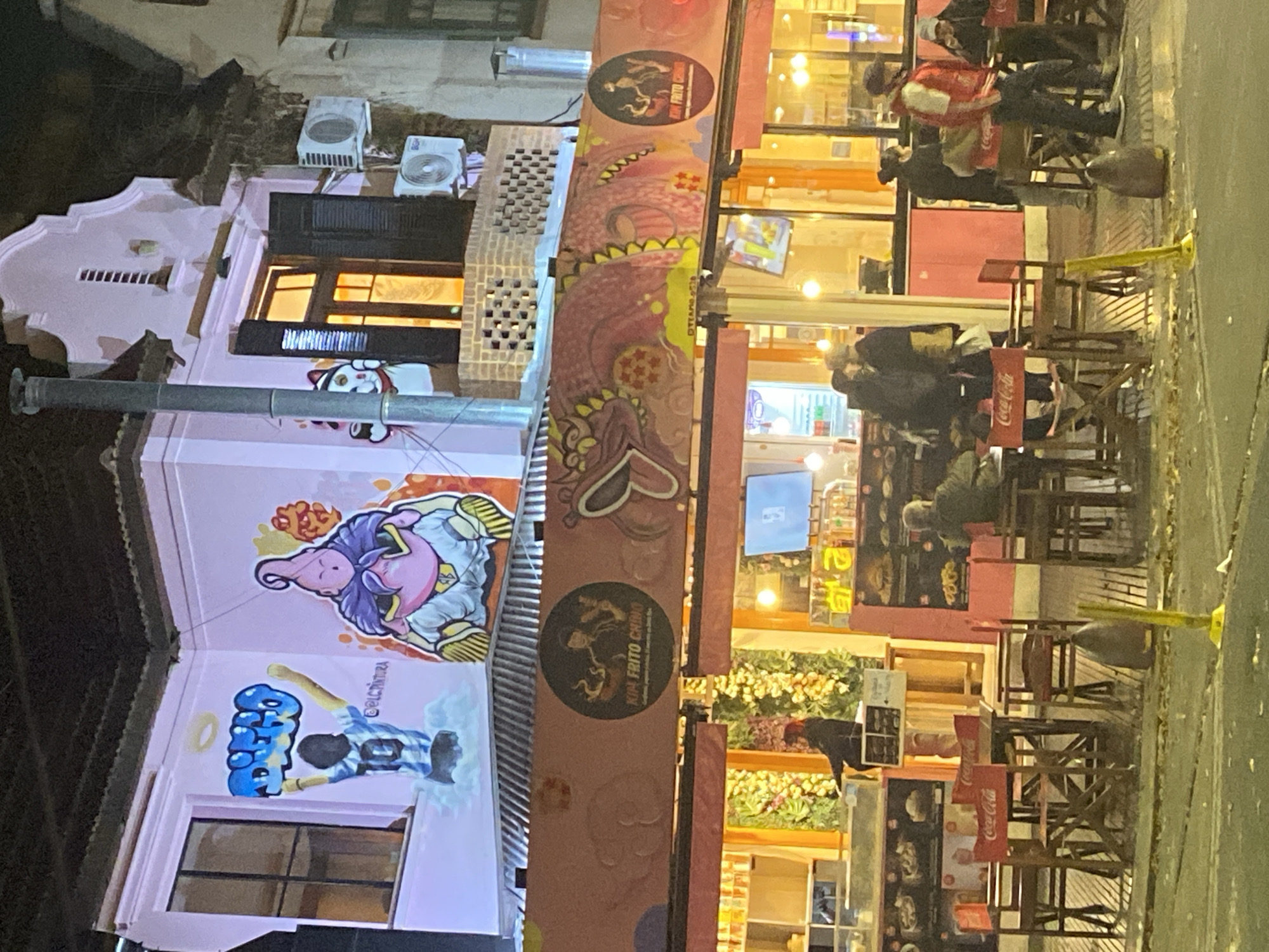 Street art murals documented on pink building in Buenos Aires