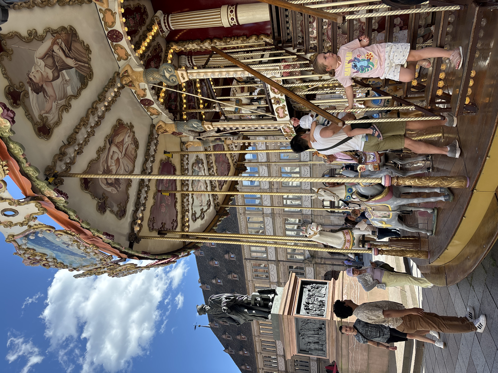 Strasbourg carousel and French bakery display on sunny afternoon