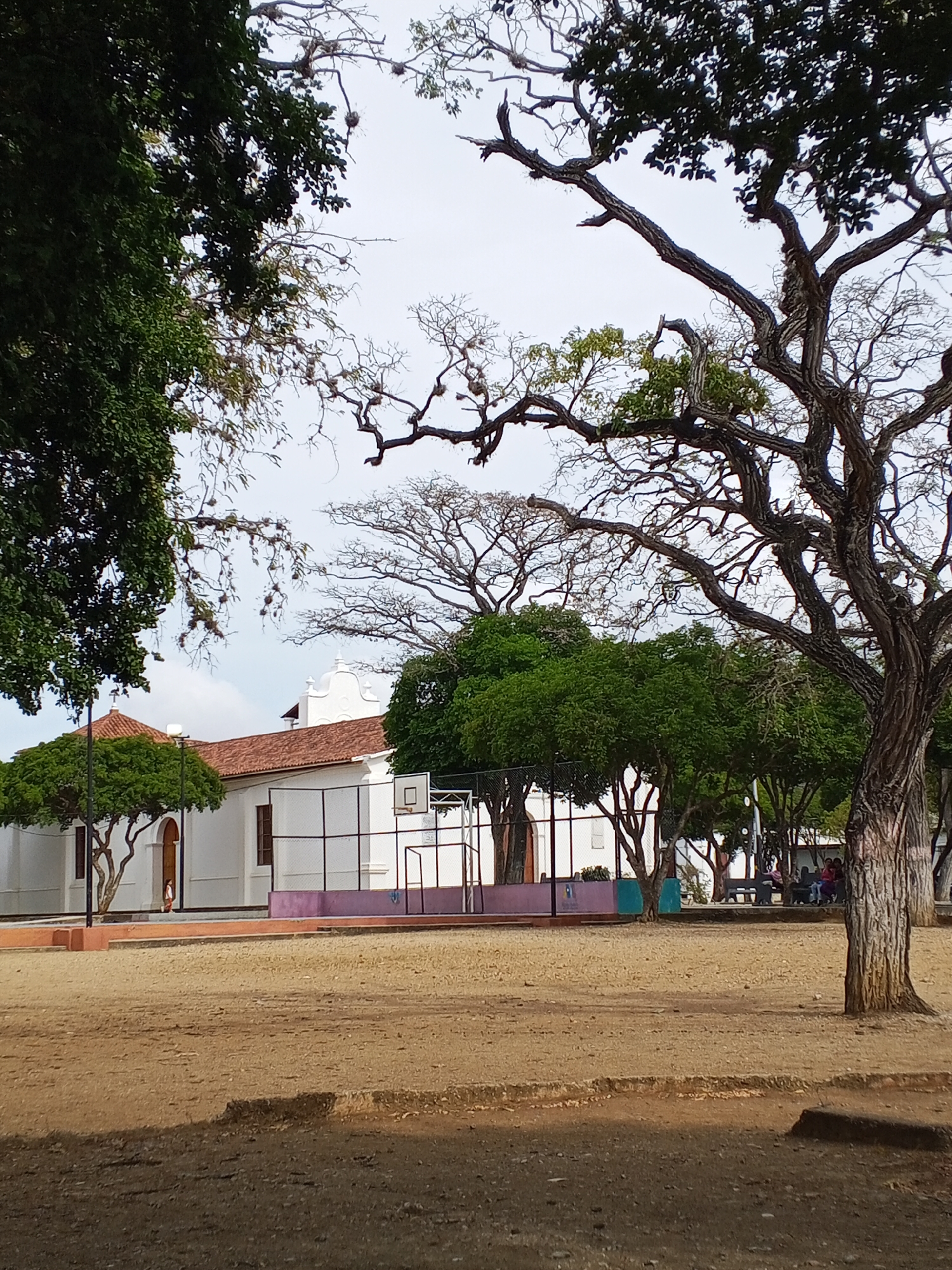 Urban plaza observed near white church building with red roof