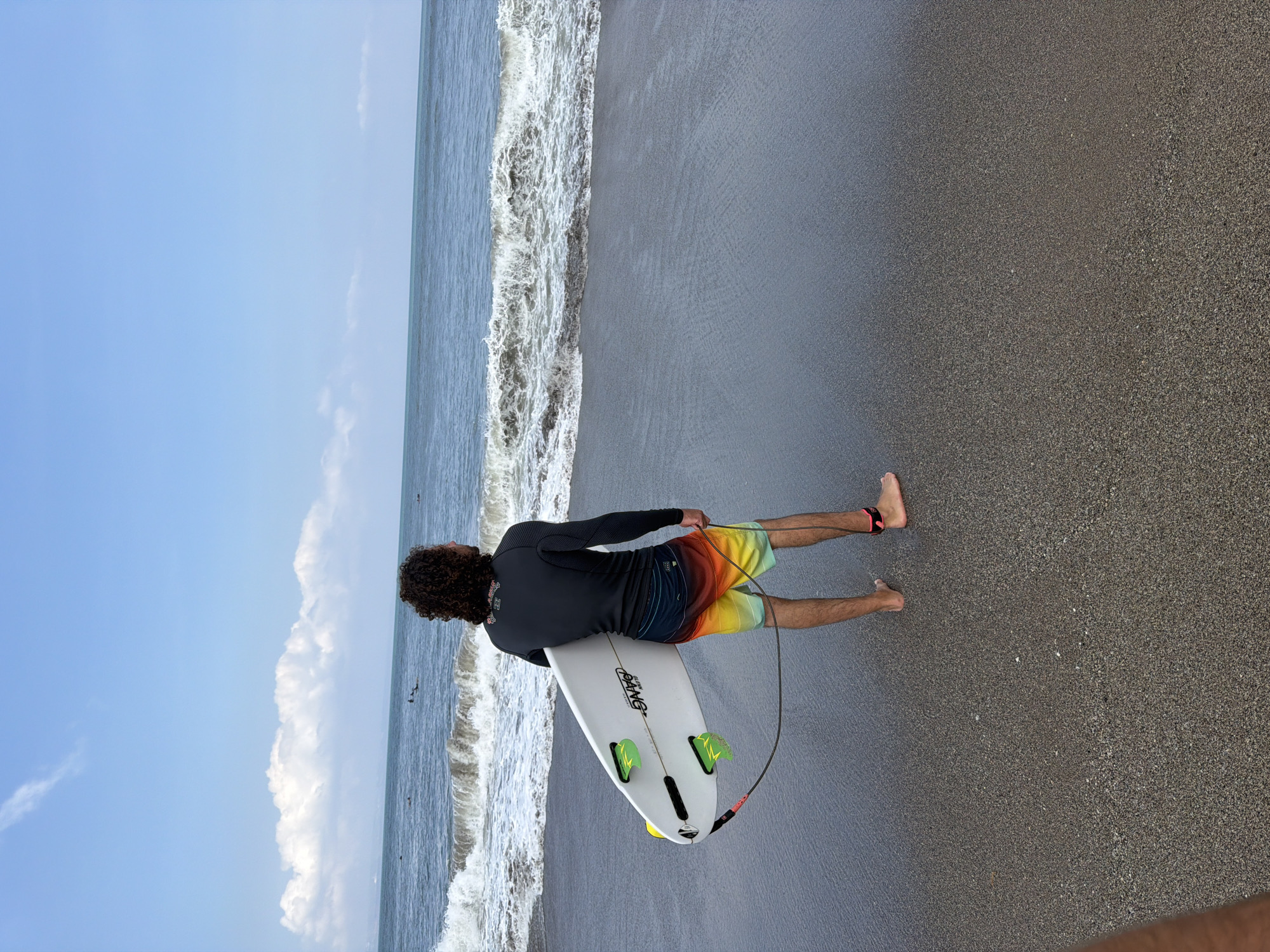 Sunny morning surf session on North Kuta's black sand beach