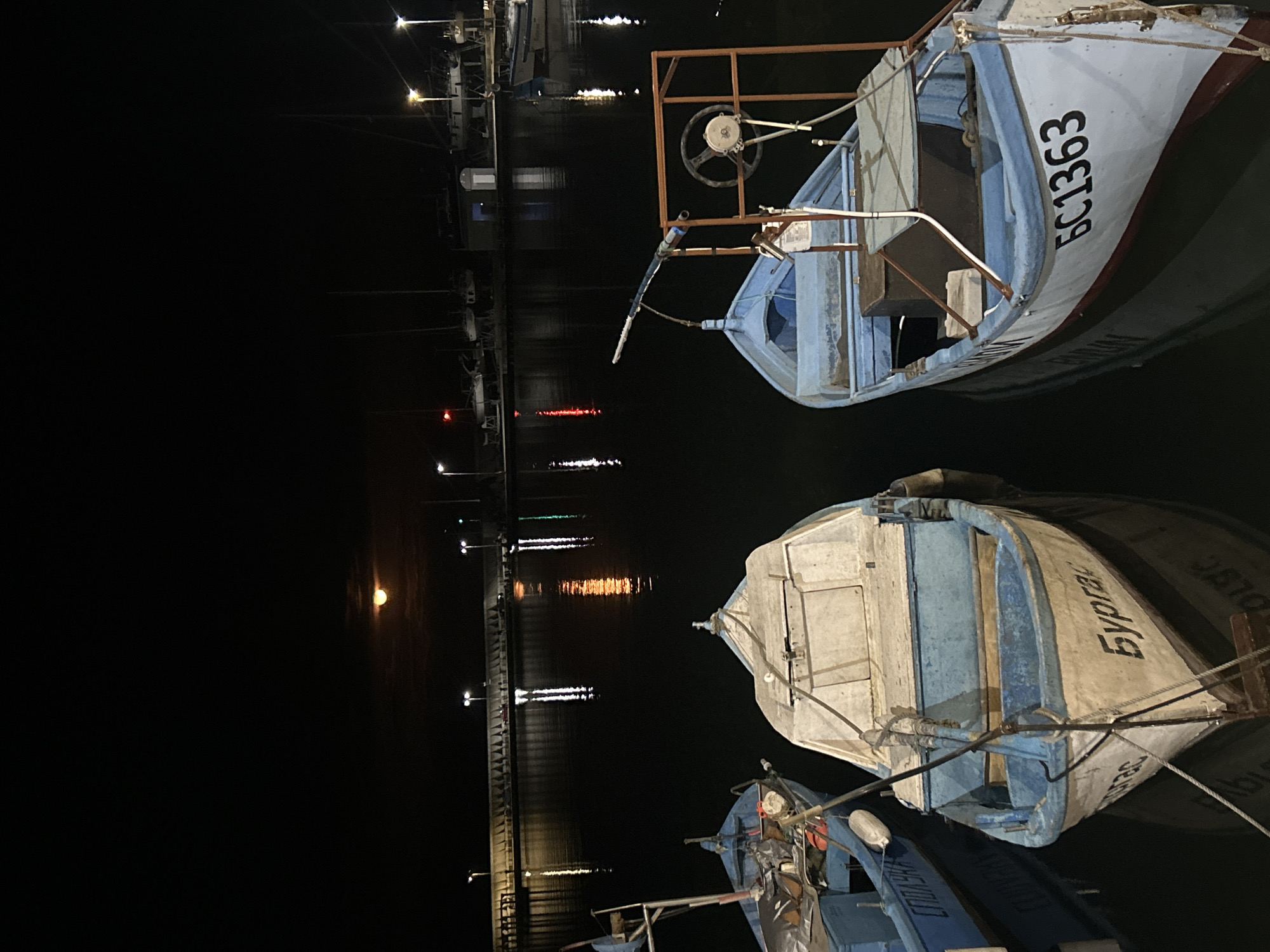 Fishing boats docked at nighttime Burgas harbor pier