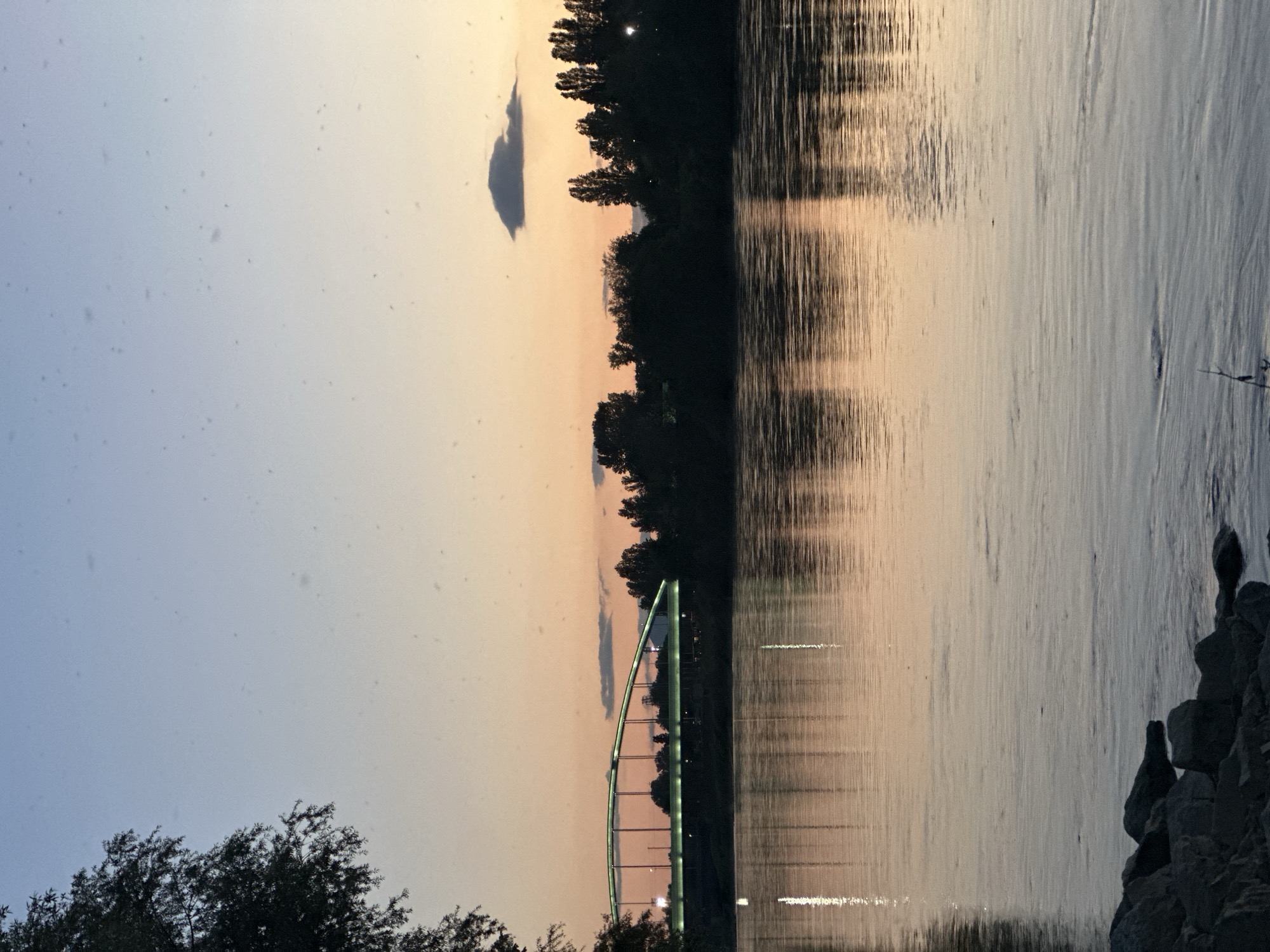 Person with face bandages photographed at Zagreb riverside during sunset