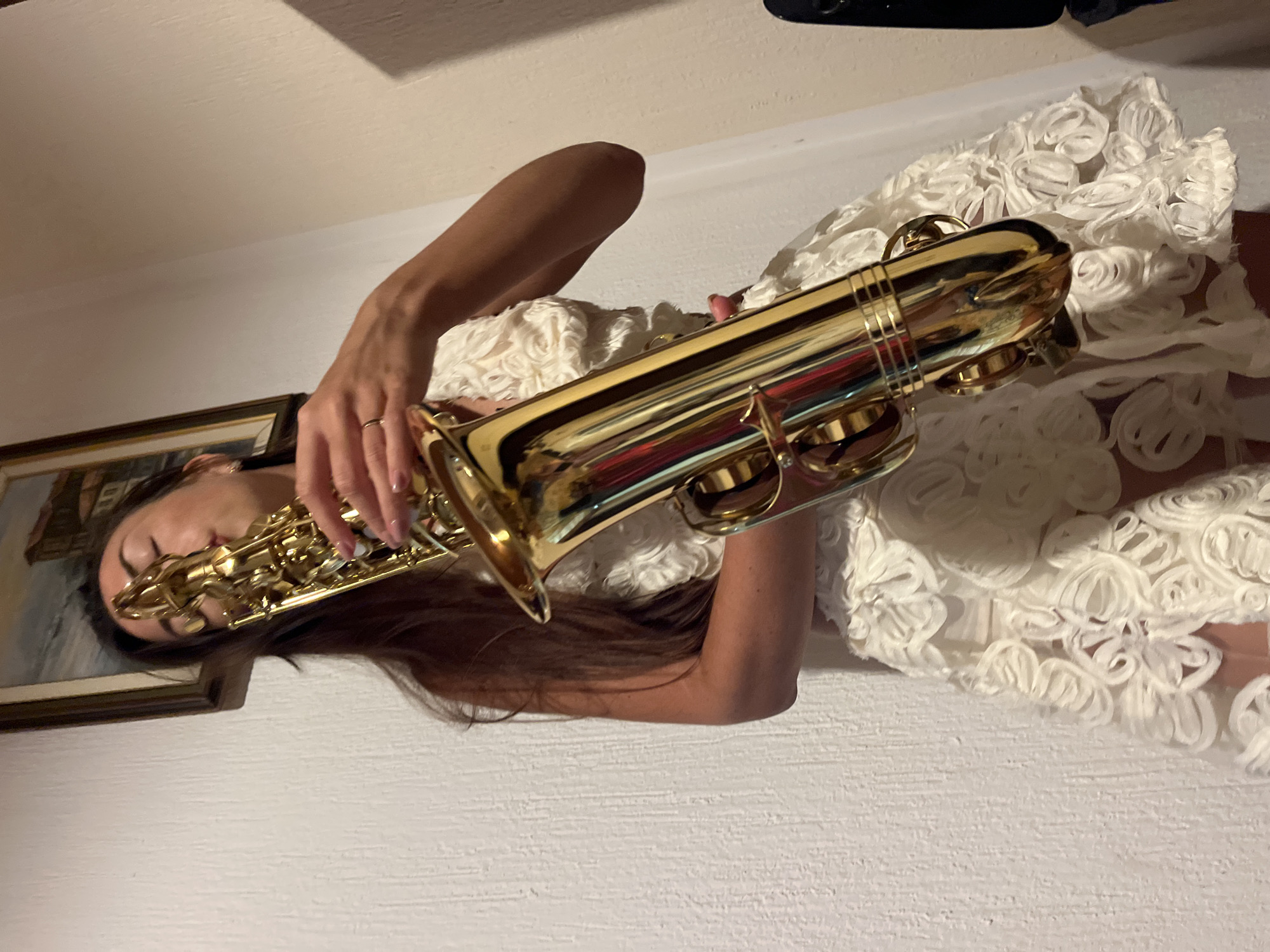Woman performs saxophone indoors in Montenegro coastal town