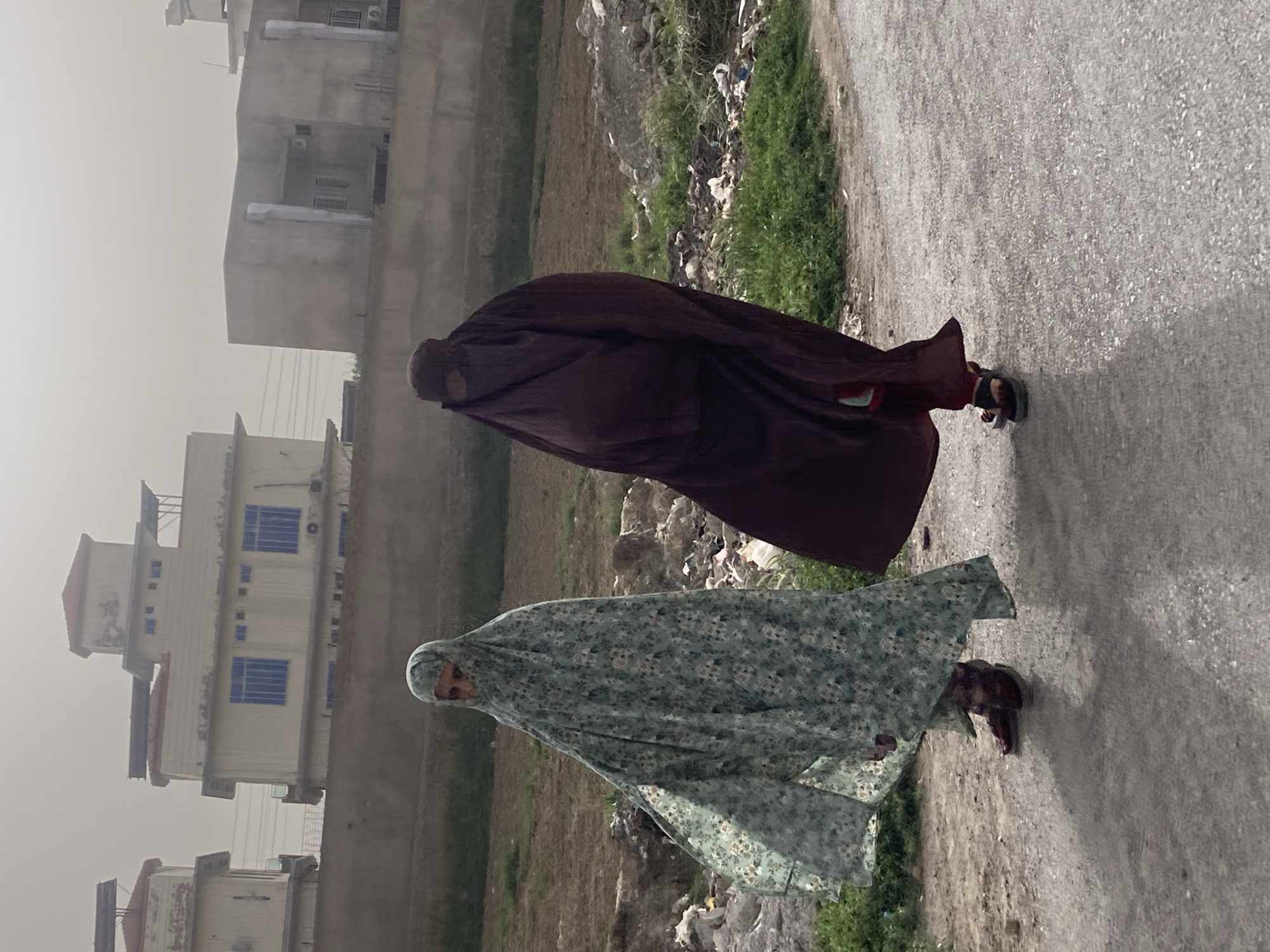 Two women in burqas walk street in Quetta