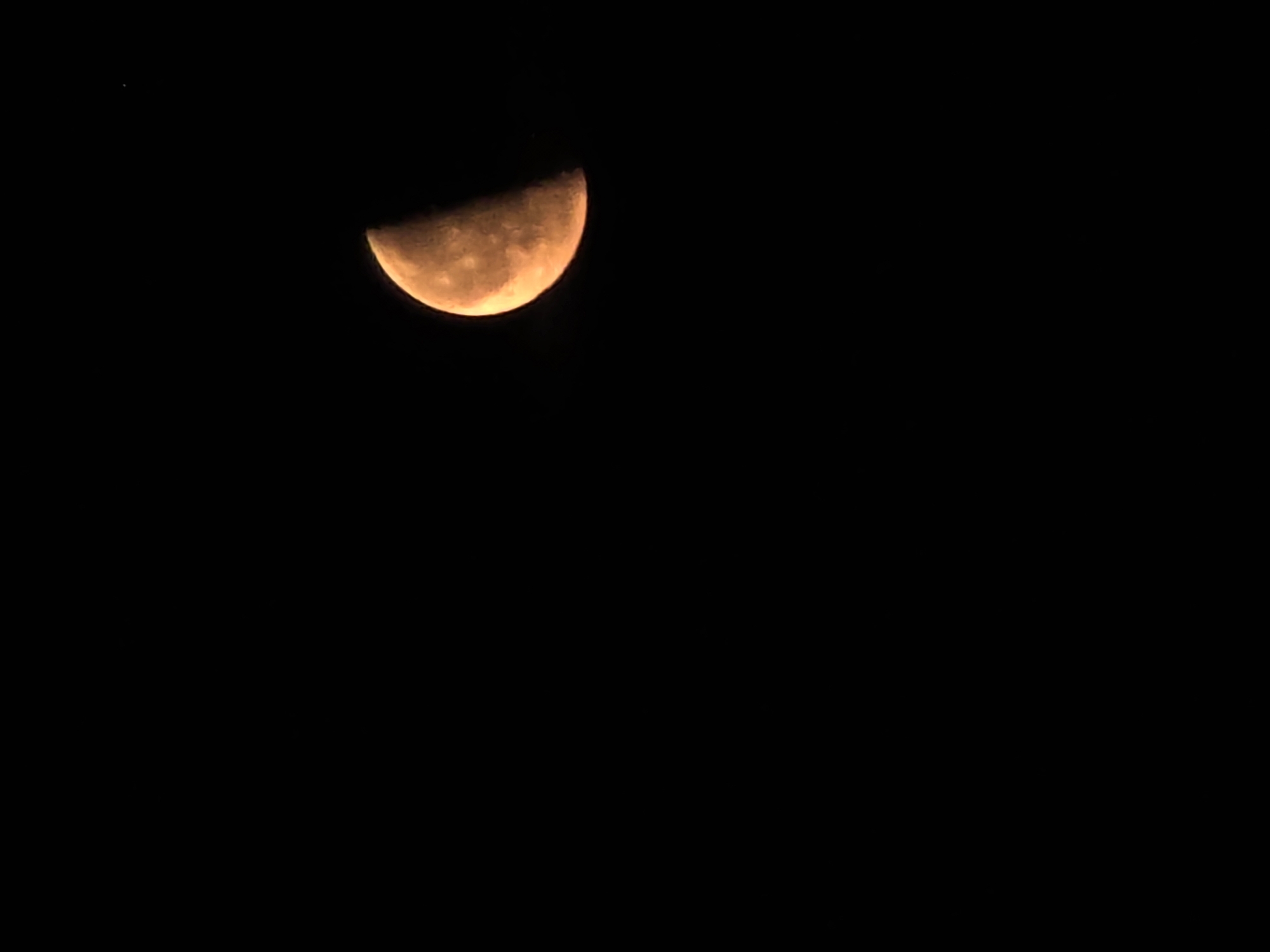 Orange moon photographed multiple ways over rural Russia at night