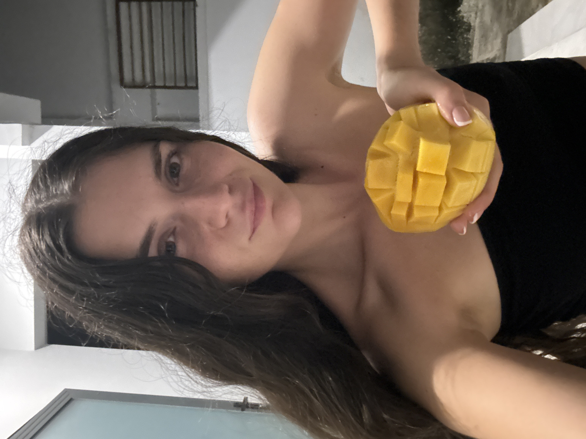 Woman prepares fresh mango indoors in Mũi Né, Vietnam