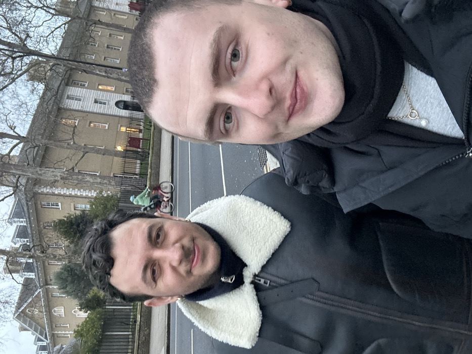Two men take selfie in overcast London afternoon
