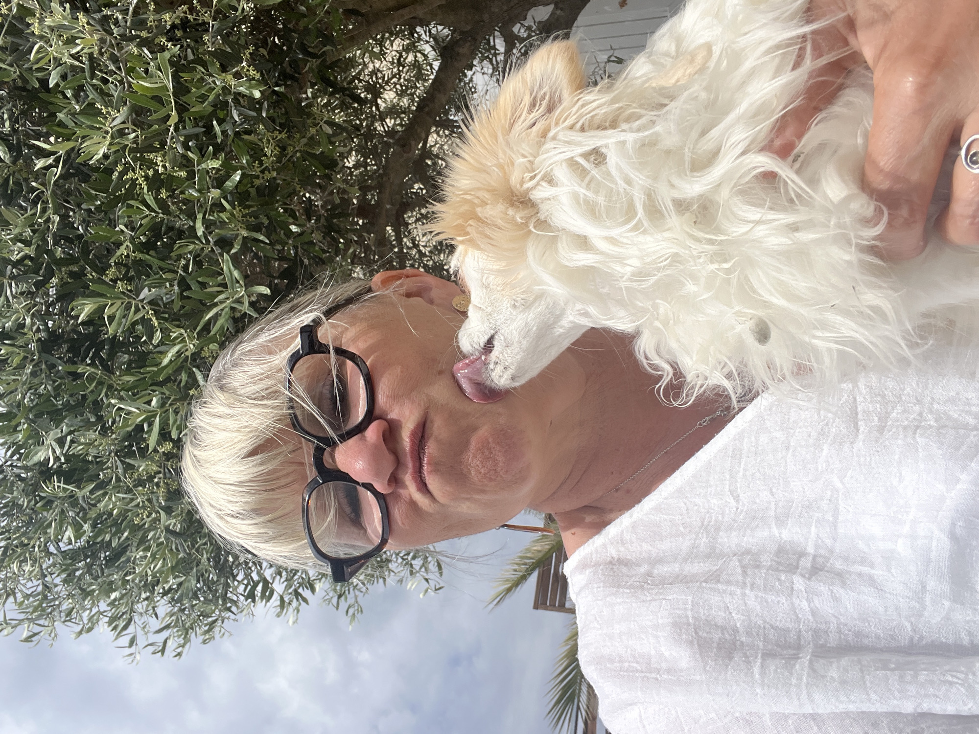 Woman and small dog share tender moments in Montarnaud