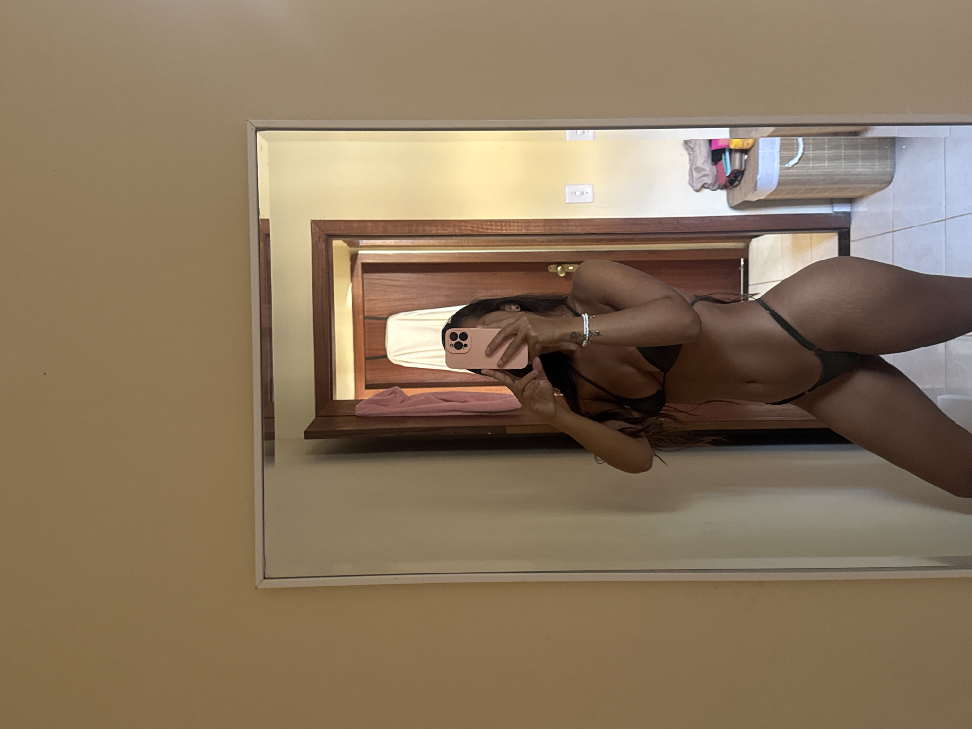 Woman takes bathroom mirror selfies in Cabo Frio, Brazil