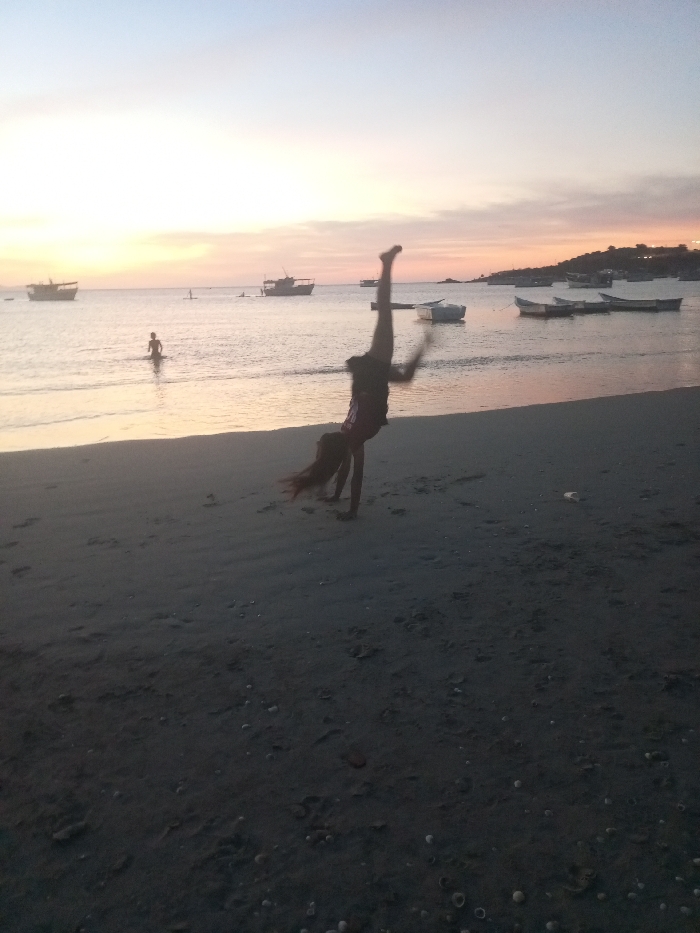Sunset beach gathering features gymnastics, hand-holding at Juan Griego