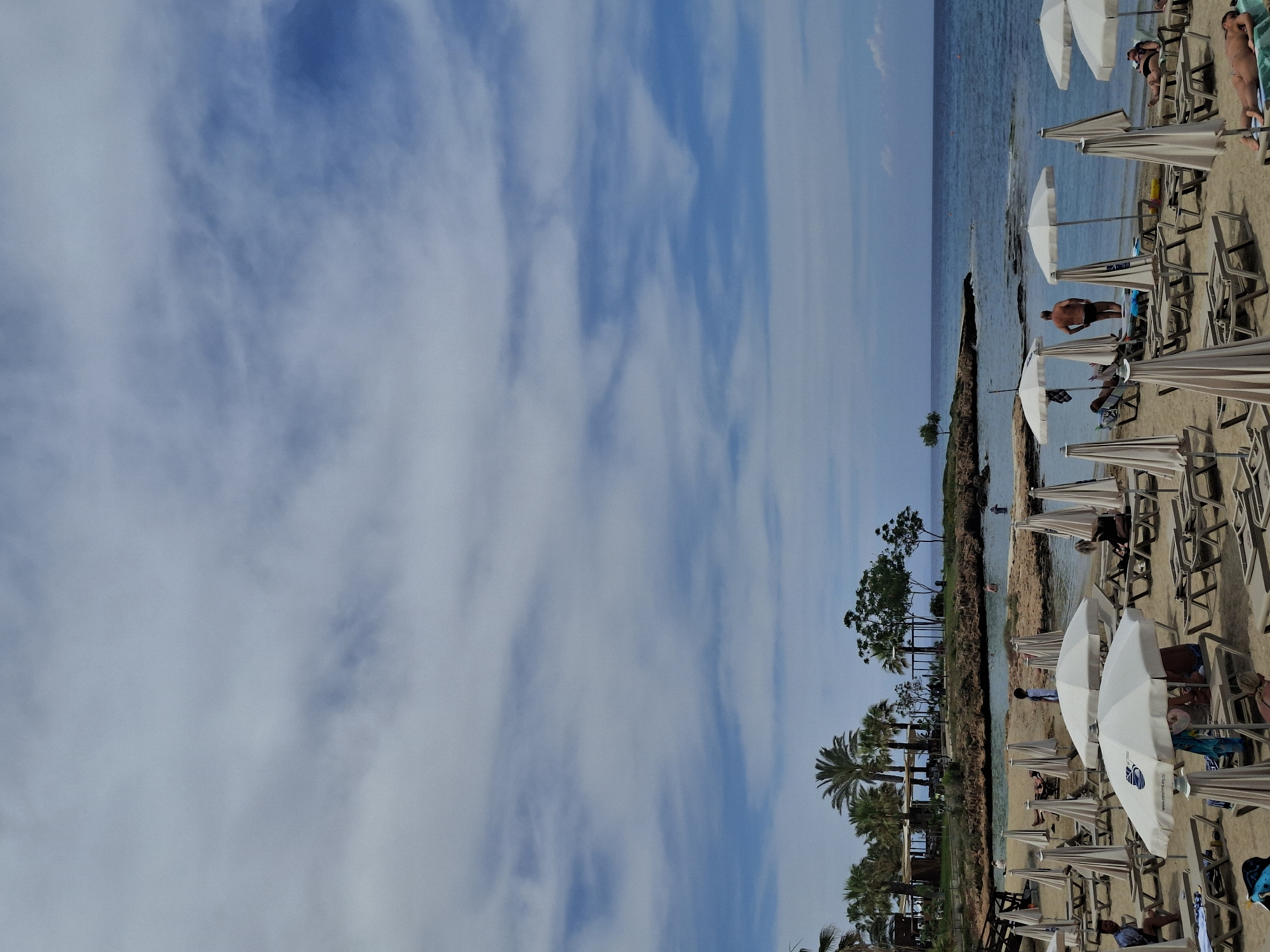 Beach scene with diagonal horizon captured under cloudy skies