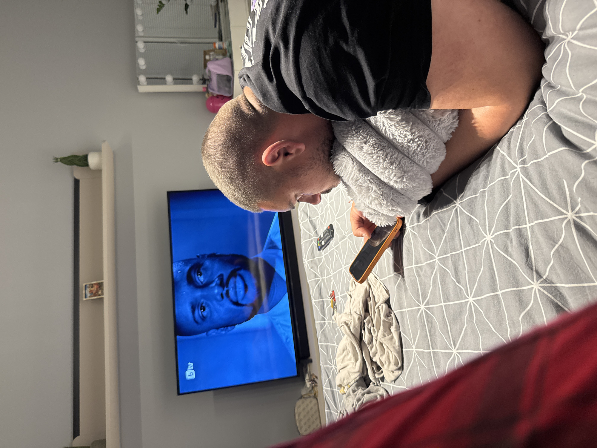 Man uses phone while resting in bed in Sofia