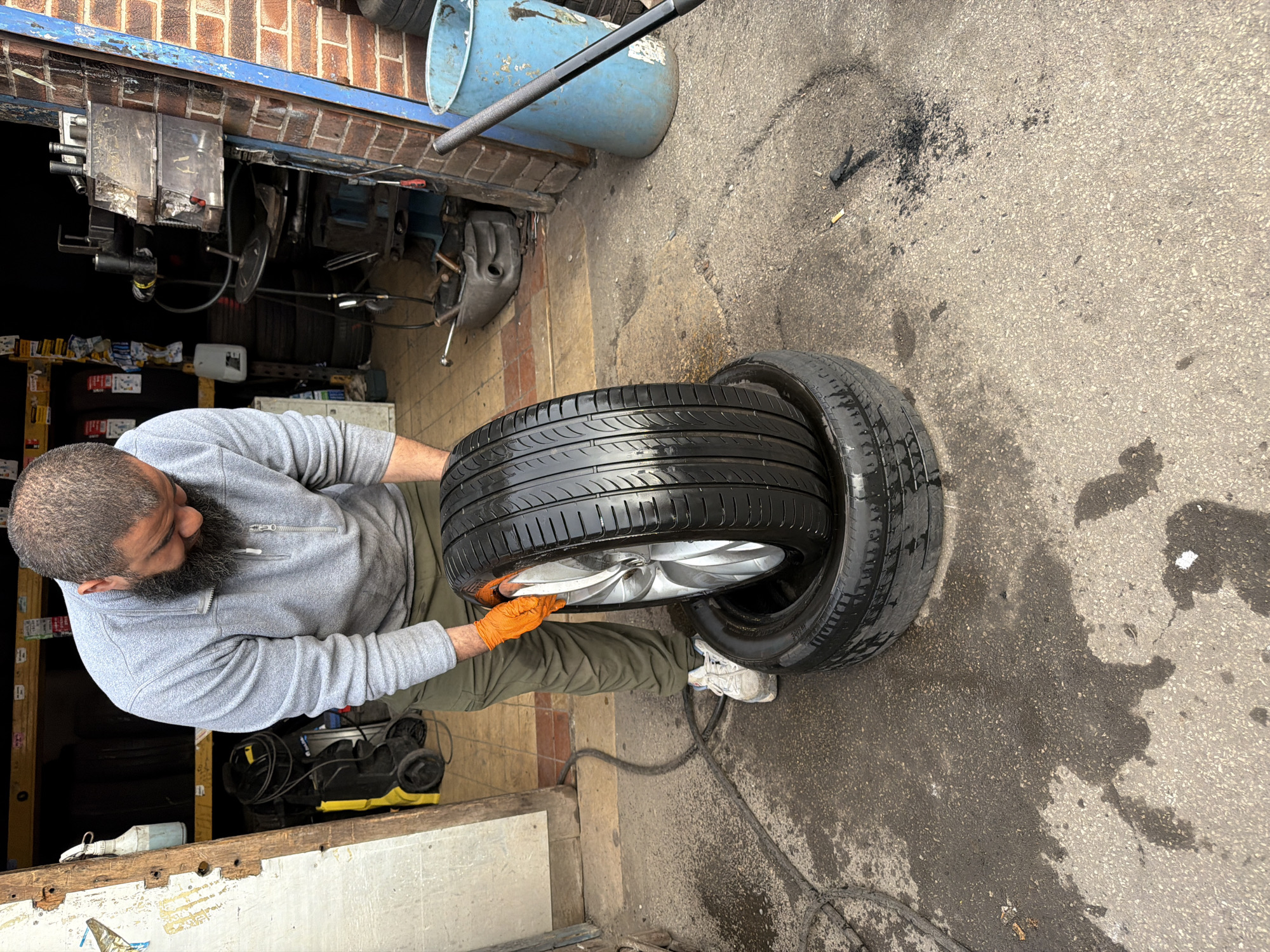 Man handles tires in garage workspace in Wakefield
