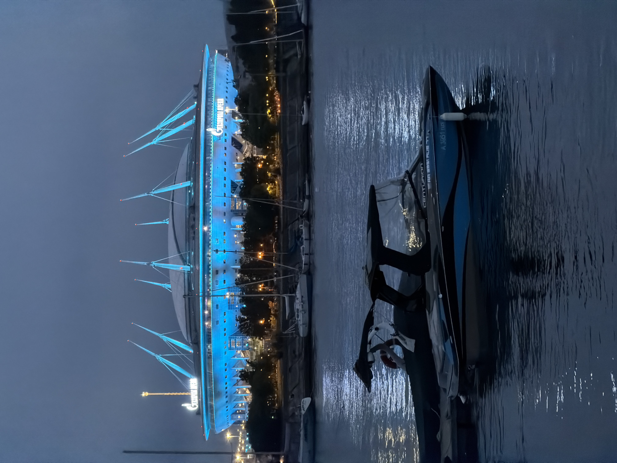 Gazprom Arena glows blue over Saint Petersburg's sailboat-filled marina