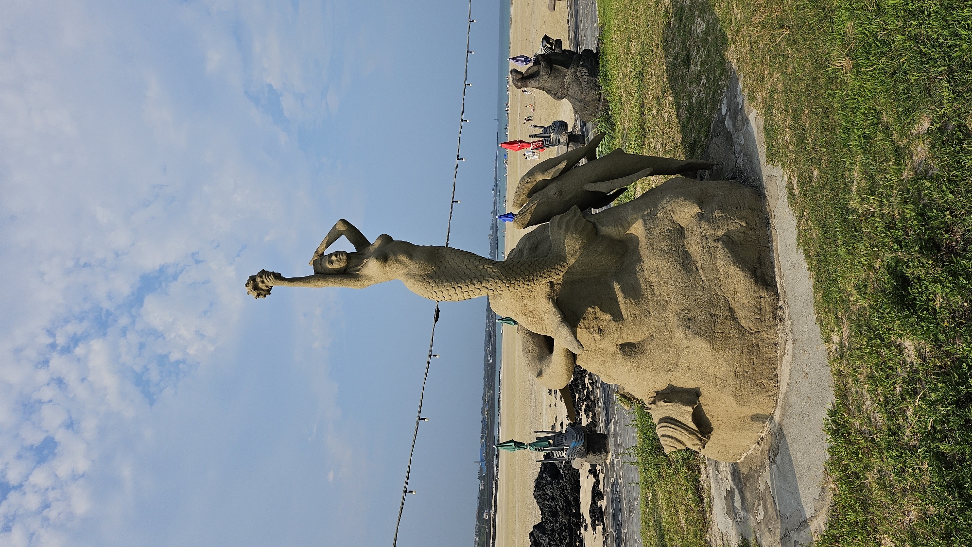 Sculptures and volcanic shoreline at a Seogwipo beach